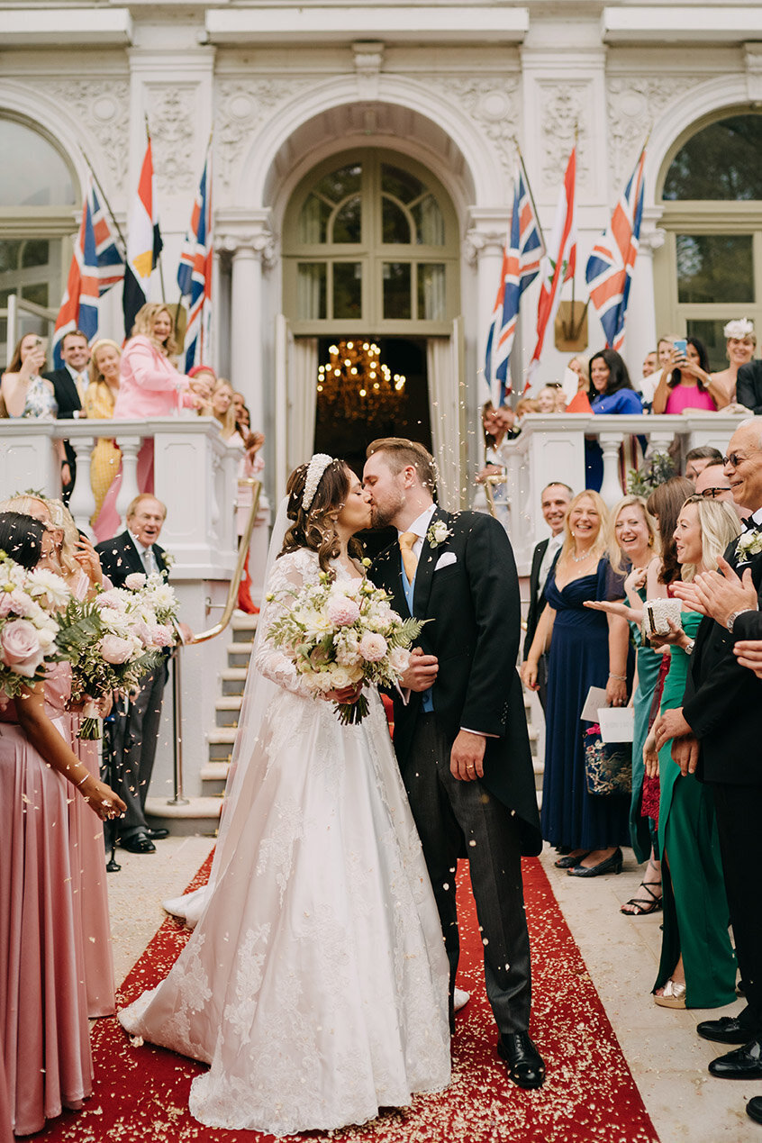 bride and groom kissing after confetti at mandarin oriental hotel wedding at royal entrance