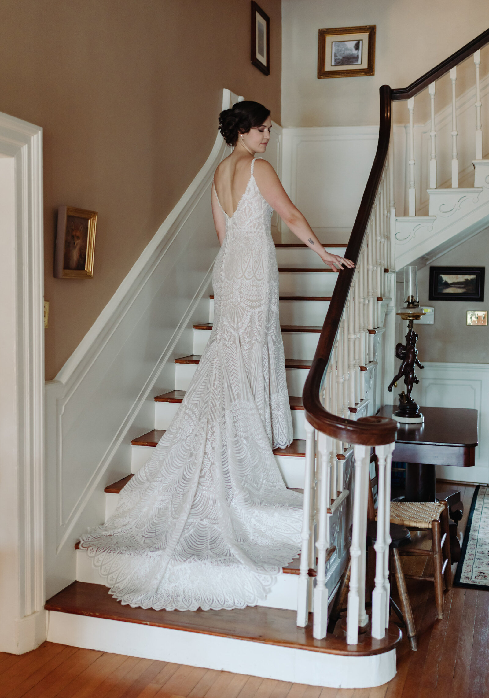 A bride stands on a grand staircase in a vintage wedding dress