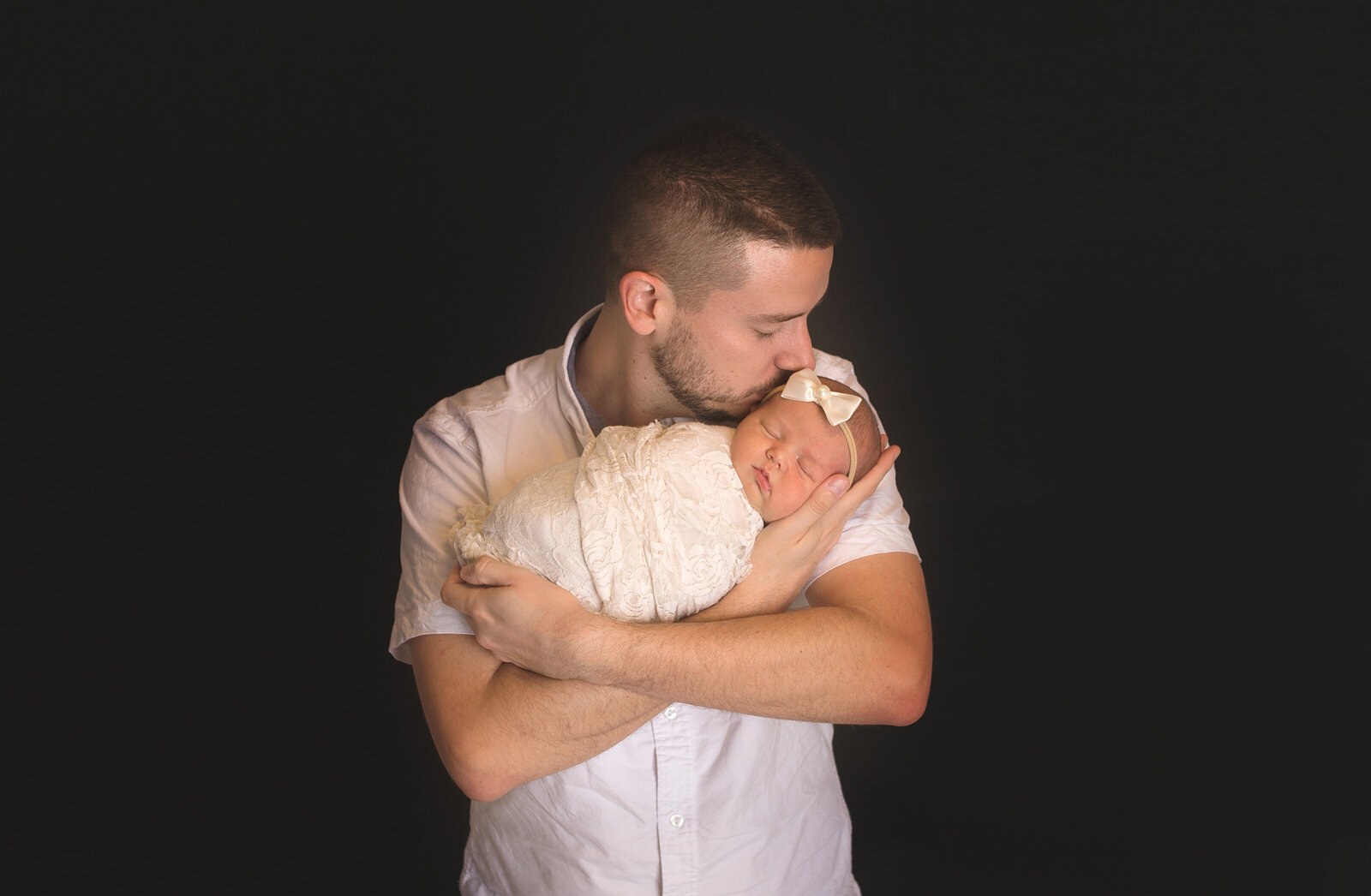 Dad holding newborn baby during newborn photoshoot with Nashville, TN newborn photographer