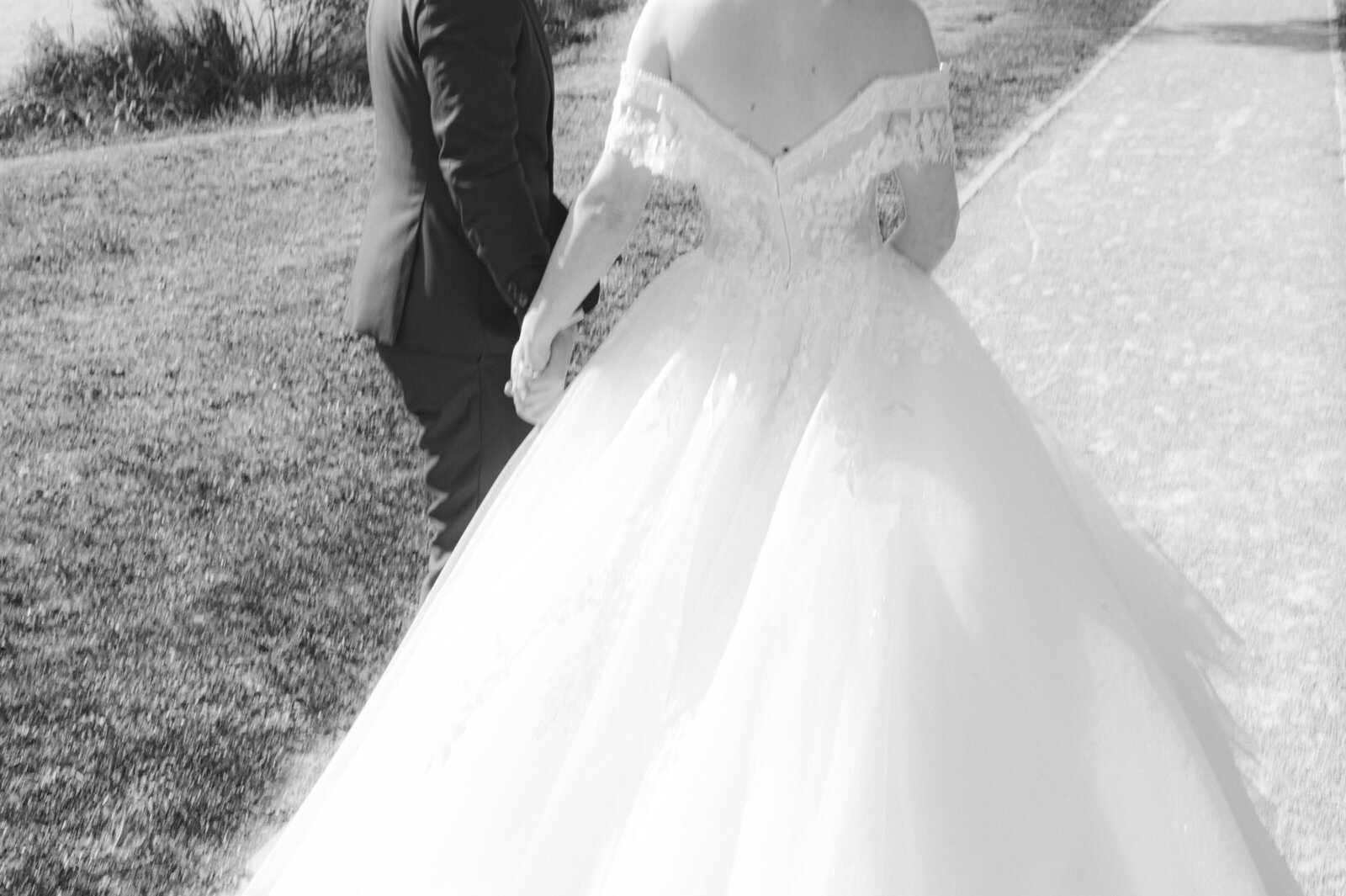 Photographie en noir et blanc d'un couple s'enfuyant de leur mariage à Paris