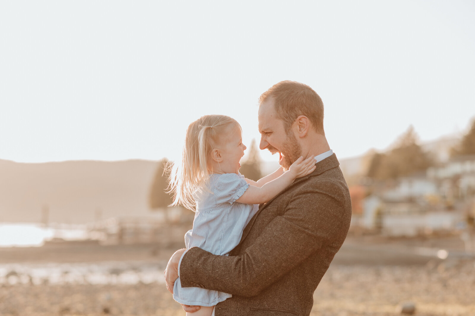 Dad and daughter laughing together on beach with Vancouver family photographer