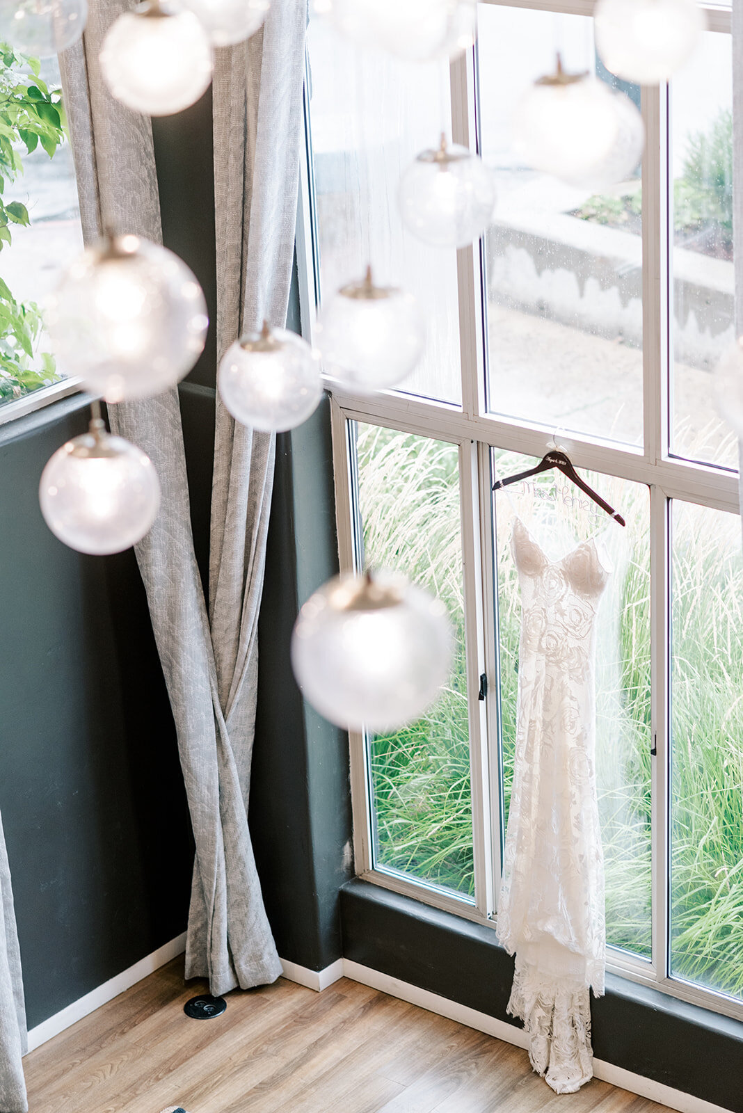 Dress hanging in the window of the Ketchum hotel during getting ready at Trail Creek Cabin Wedding taken by the Best Sun Valley Wedding Photographers