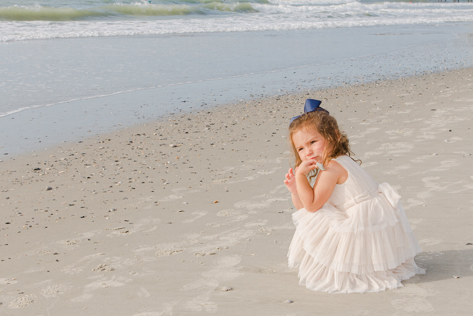 Early Easter morning children's beach photography.  Little girl wearing Easter dress on beach with Ron Schroll Photography at Pawleys Island, SC