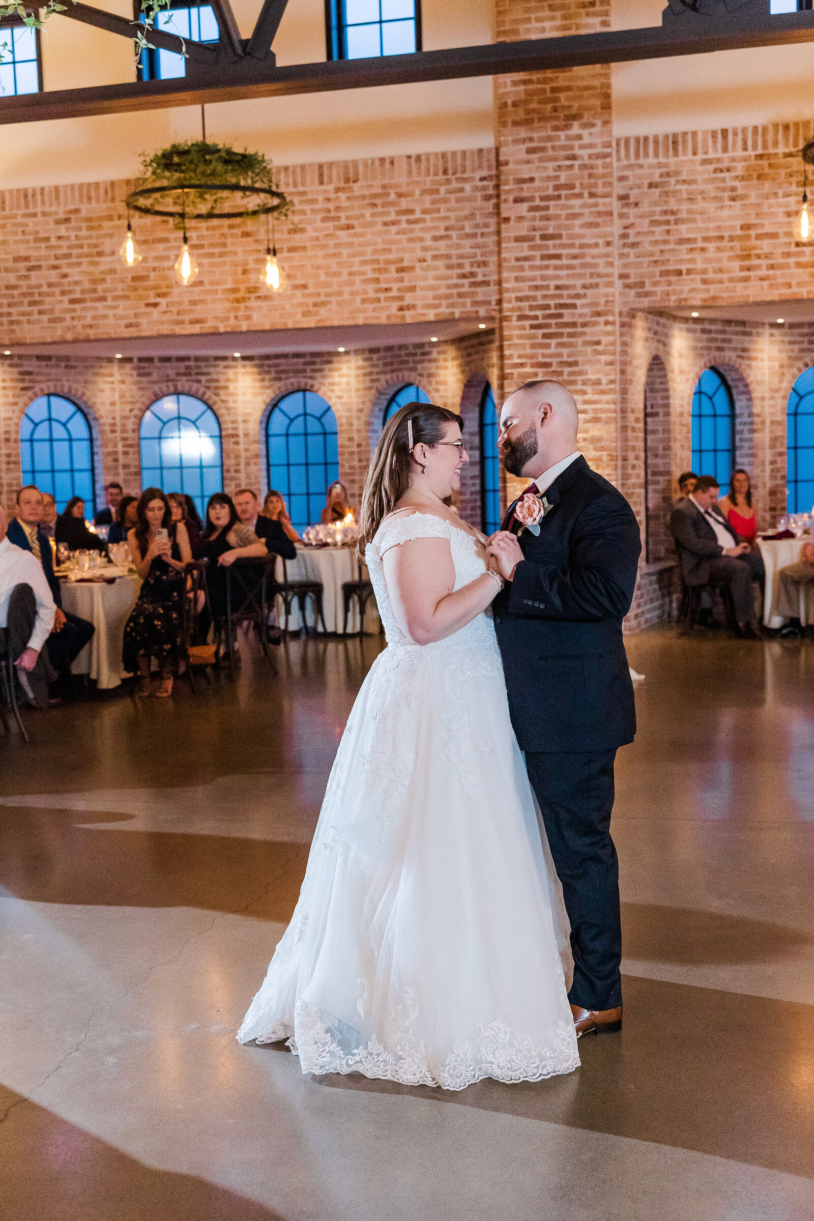 Wide-angle view of bride and groom’s first dance surrounded by guests at their Perona Farms wedding
