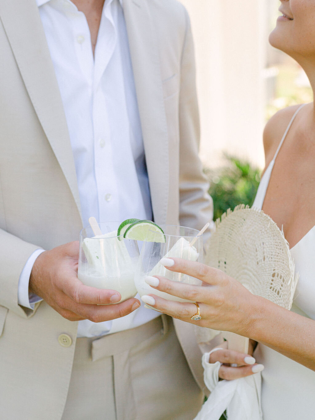 Bride and groom with icepops in a glass at summer wedding at Rosemary beach Florida