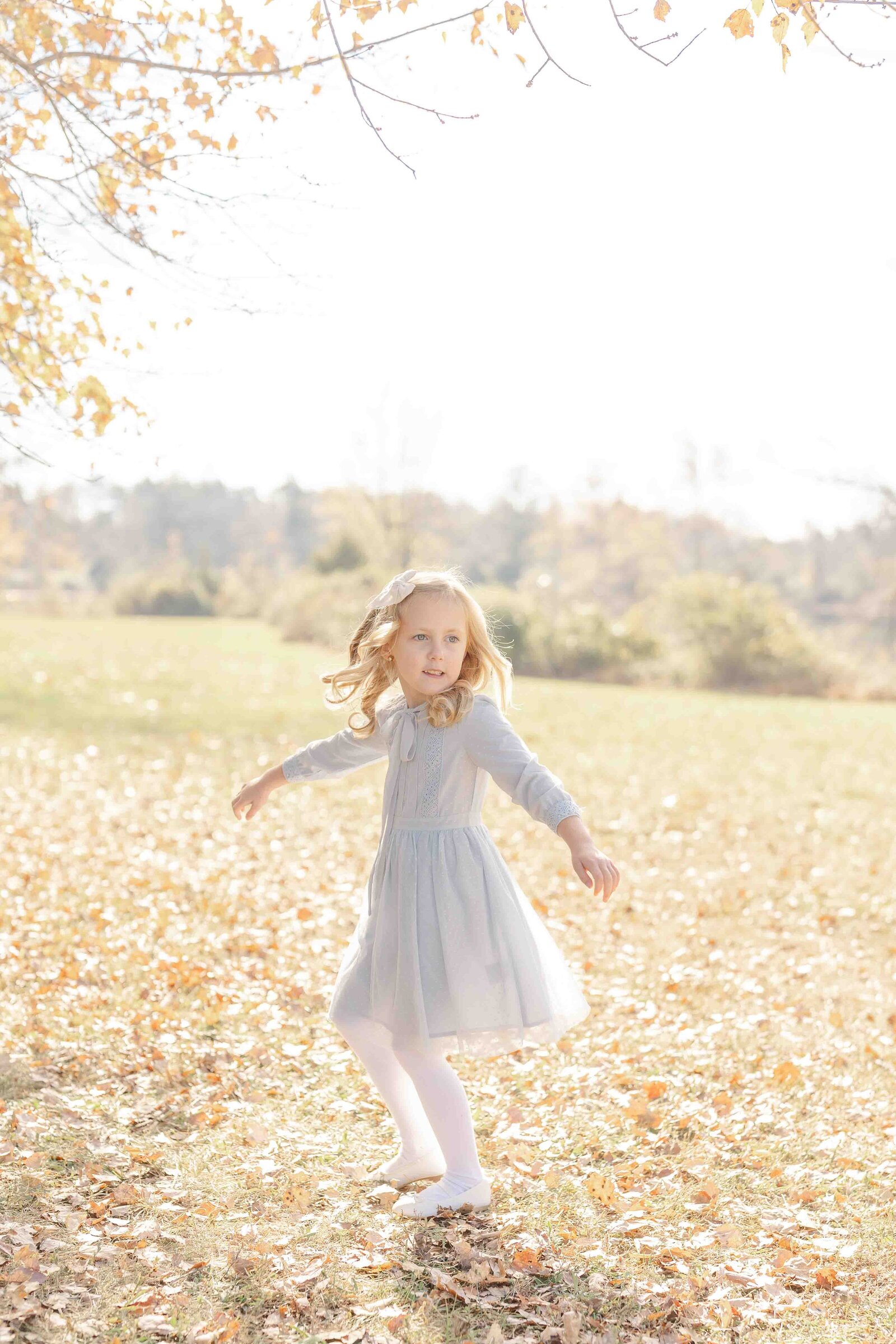 girl twirling during fall mini session in Prince William County, Virginia