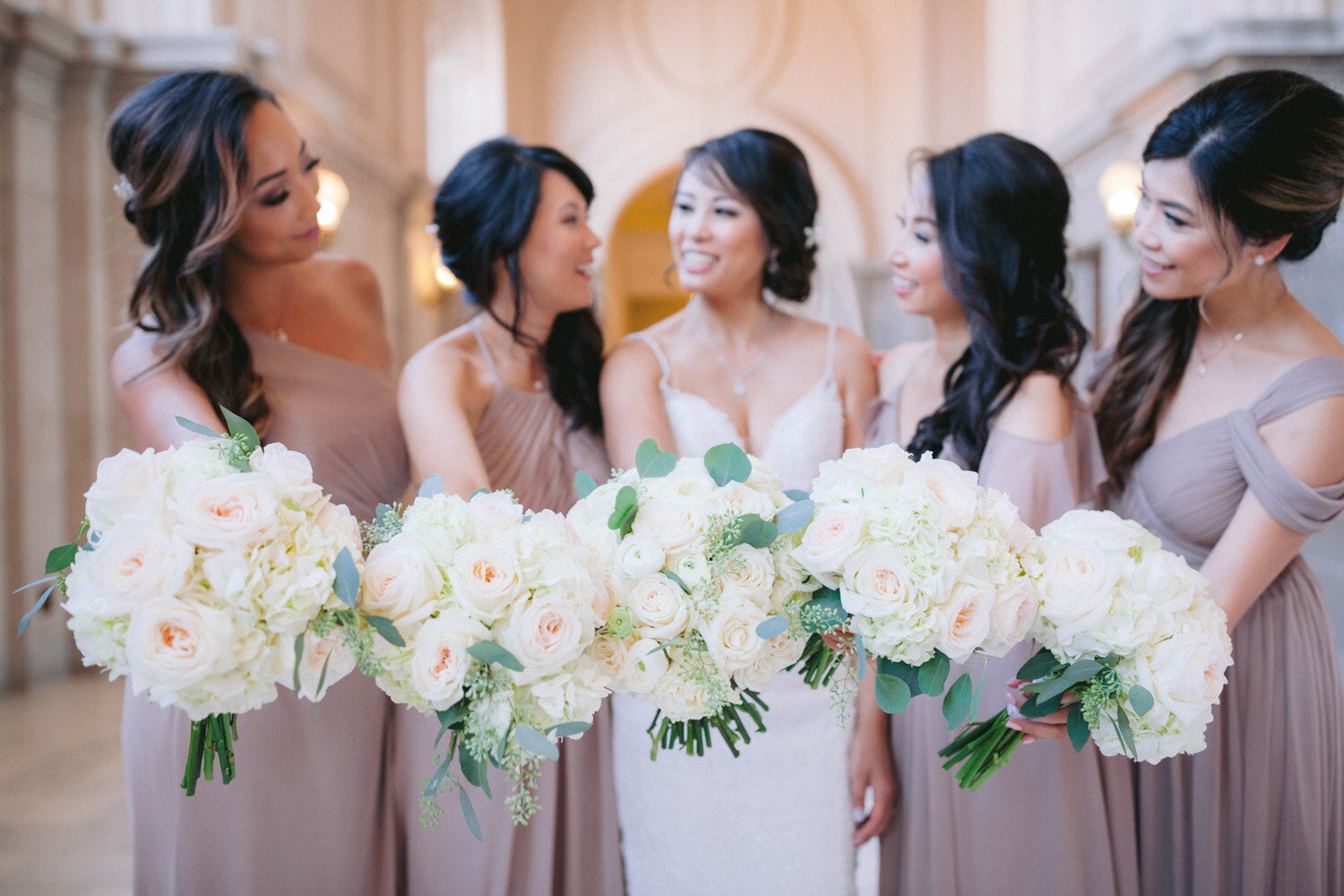 Bridesmaids holding white rose and hydrangea bouquets