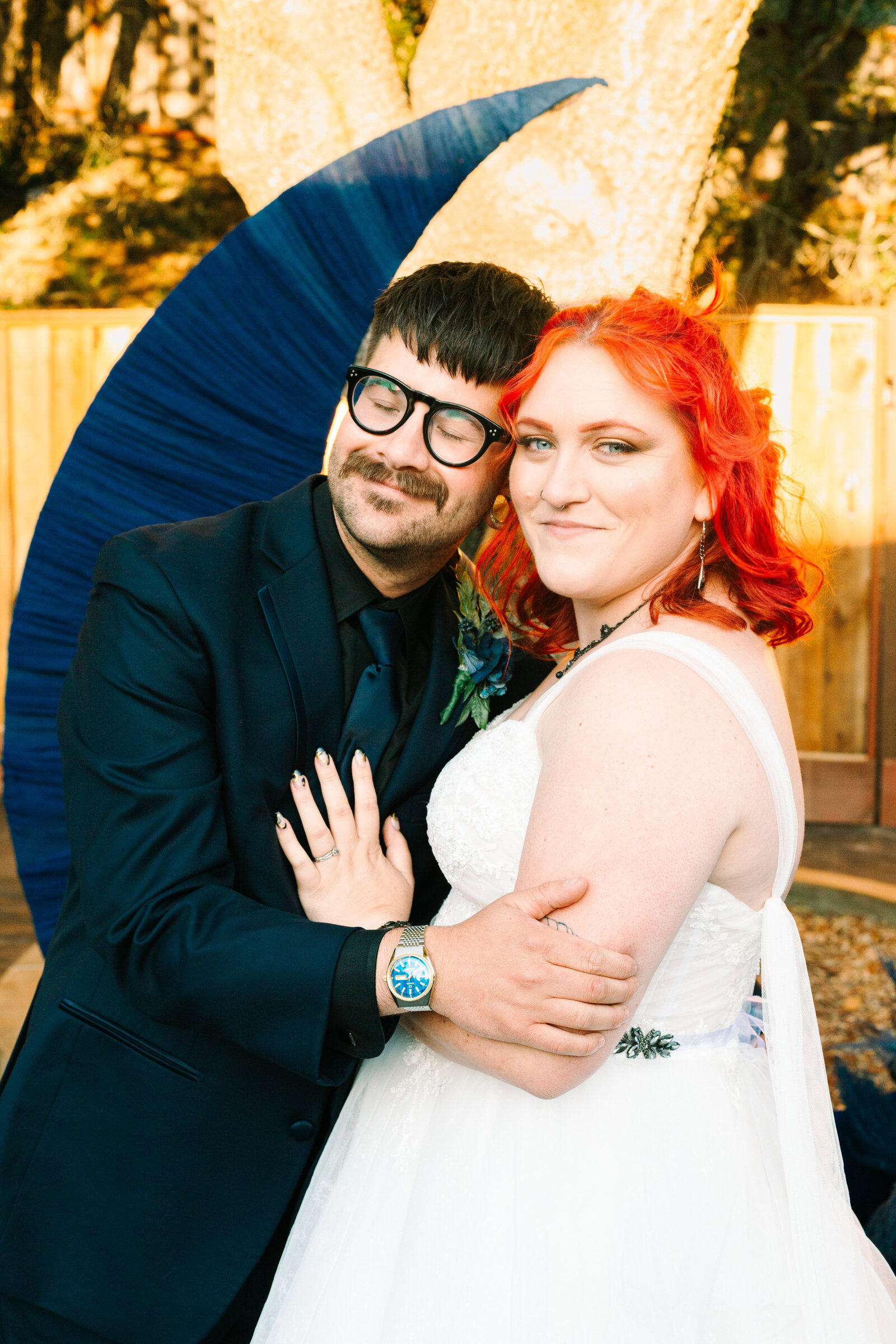 A night under the stars themed wedding, with a moon cutout. A newlywed bride and groom.