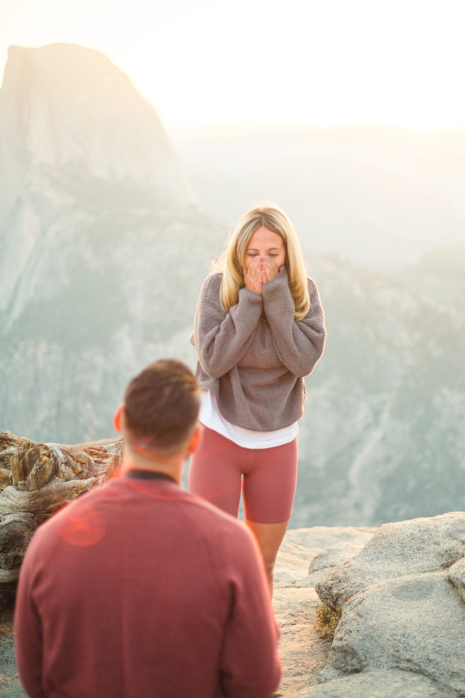 A wedding proposal between two hikers at sunrise in front of Half Dome in Yosemite National Park.