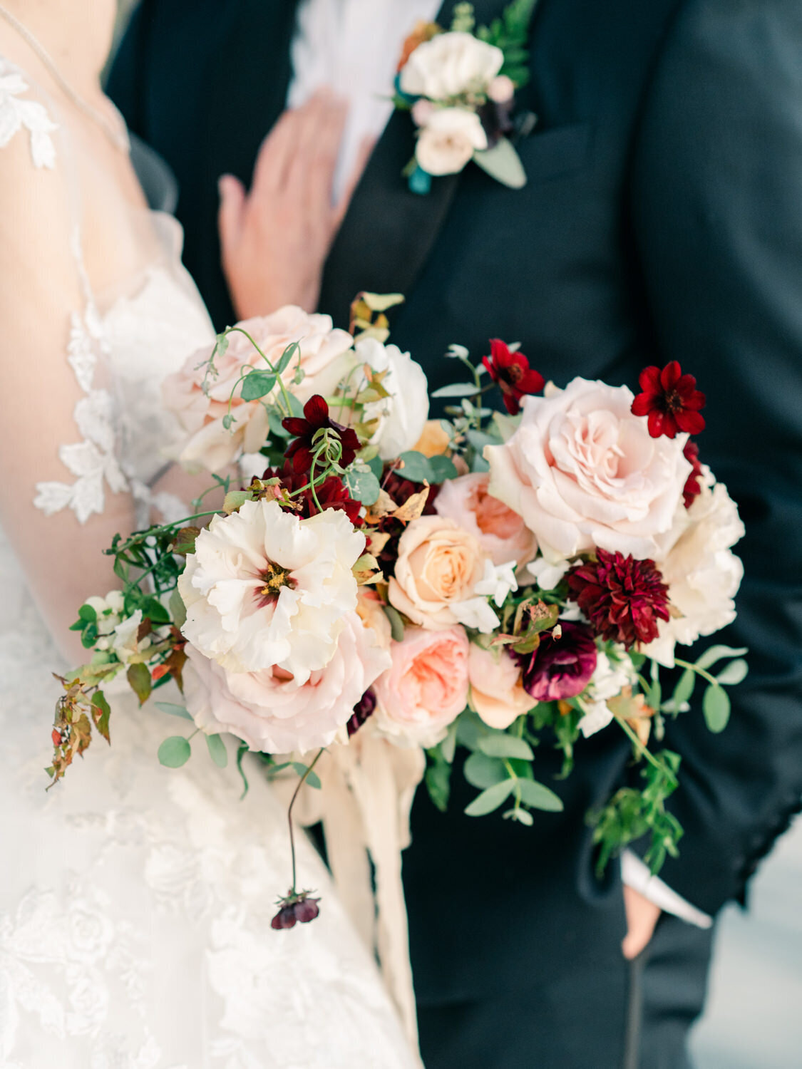 Luxury fall florals held by the bride and groom.
