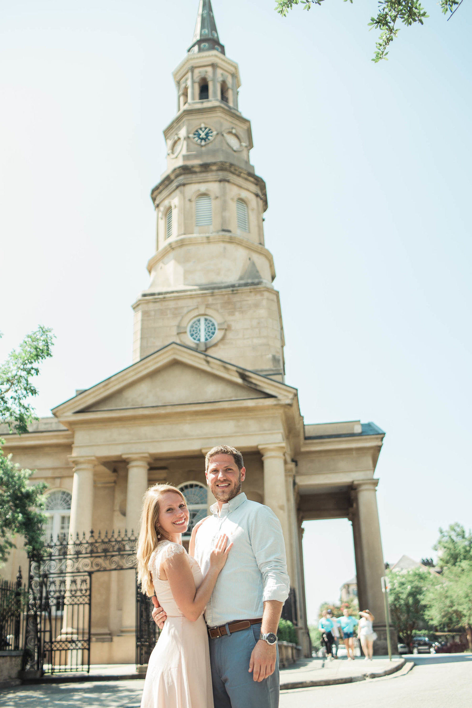 Engaged couple walk down sidewalk by St Philip's Episcopal Church, Downtown Charleston, South Carolina