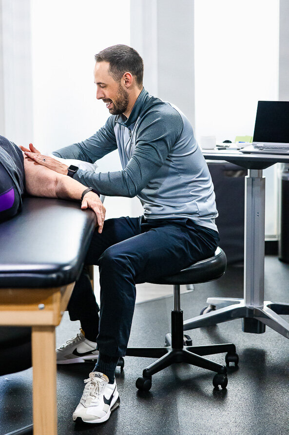 Chiropractor works on a woman's shoulder.