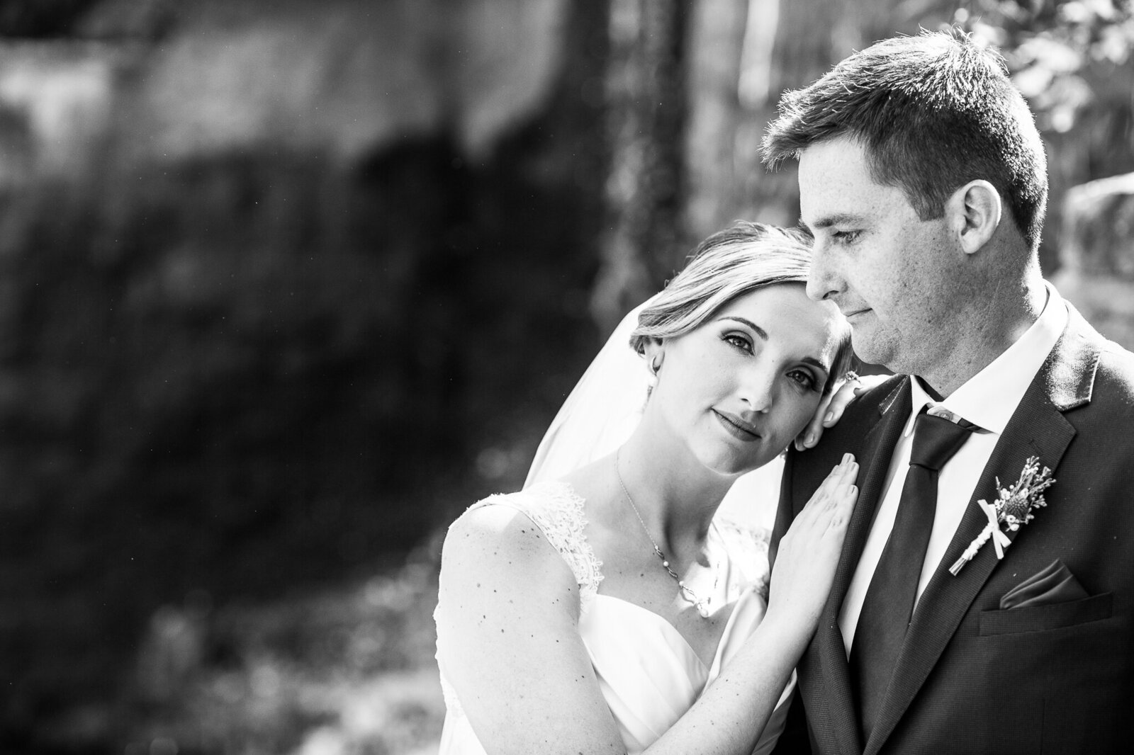 Bride and groom in front of waterfall at Ancaster Mill