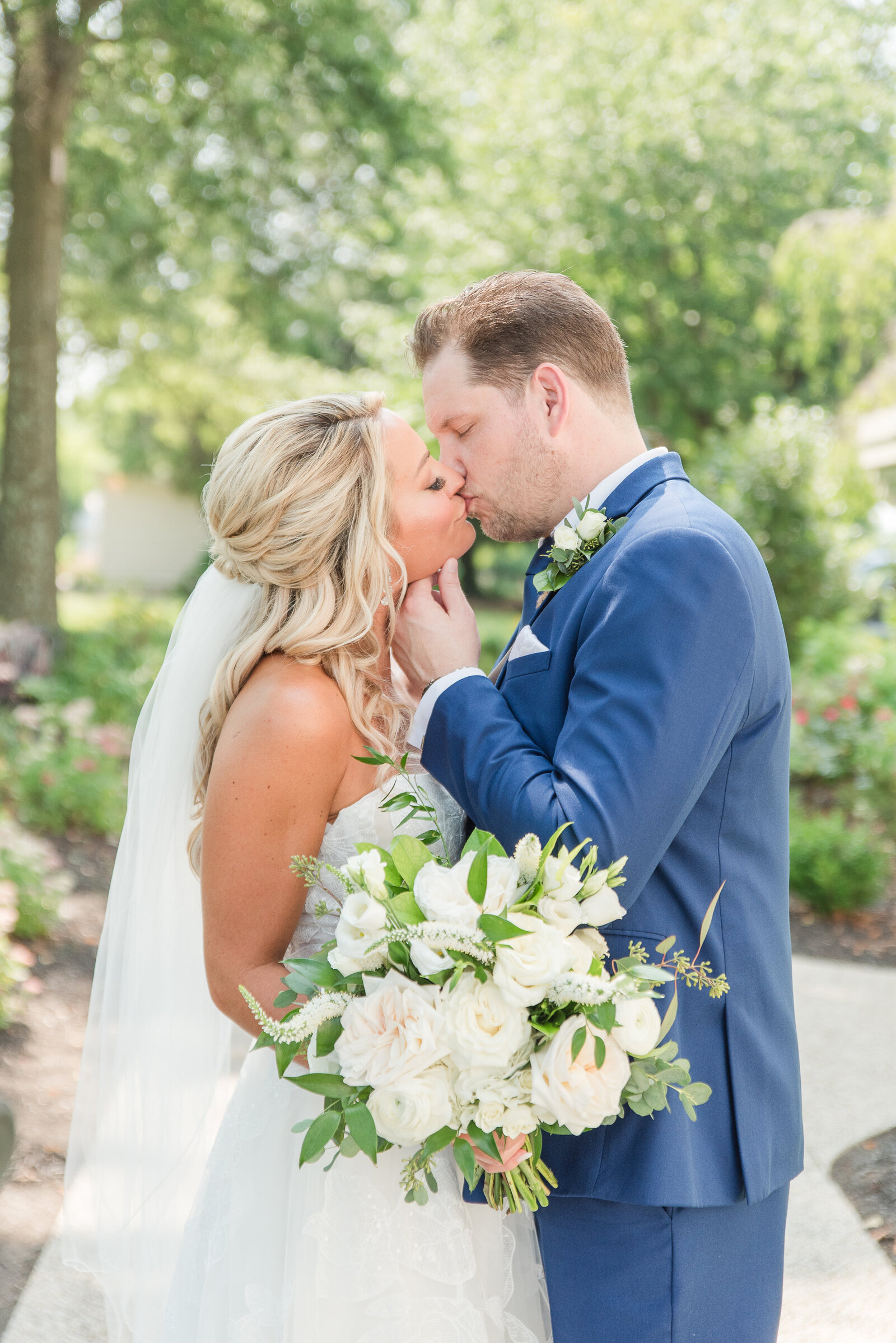 couple kissing on wedding day in the summer