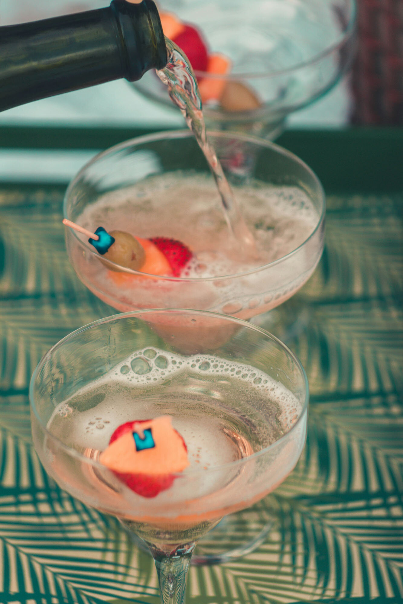 Two martini glasses with strawberries and grapes in them