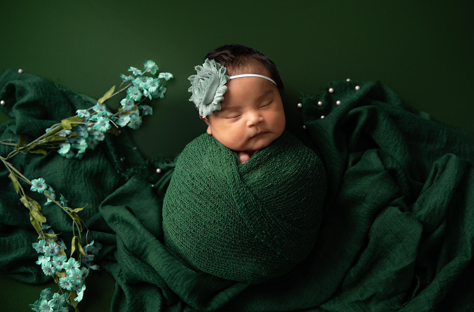 newborn wrapped in green wrap