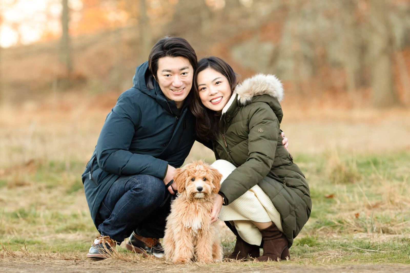 Japanese couple with their Golden Doodle puppy in the woods near Boston posing for pet photos