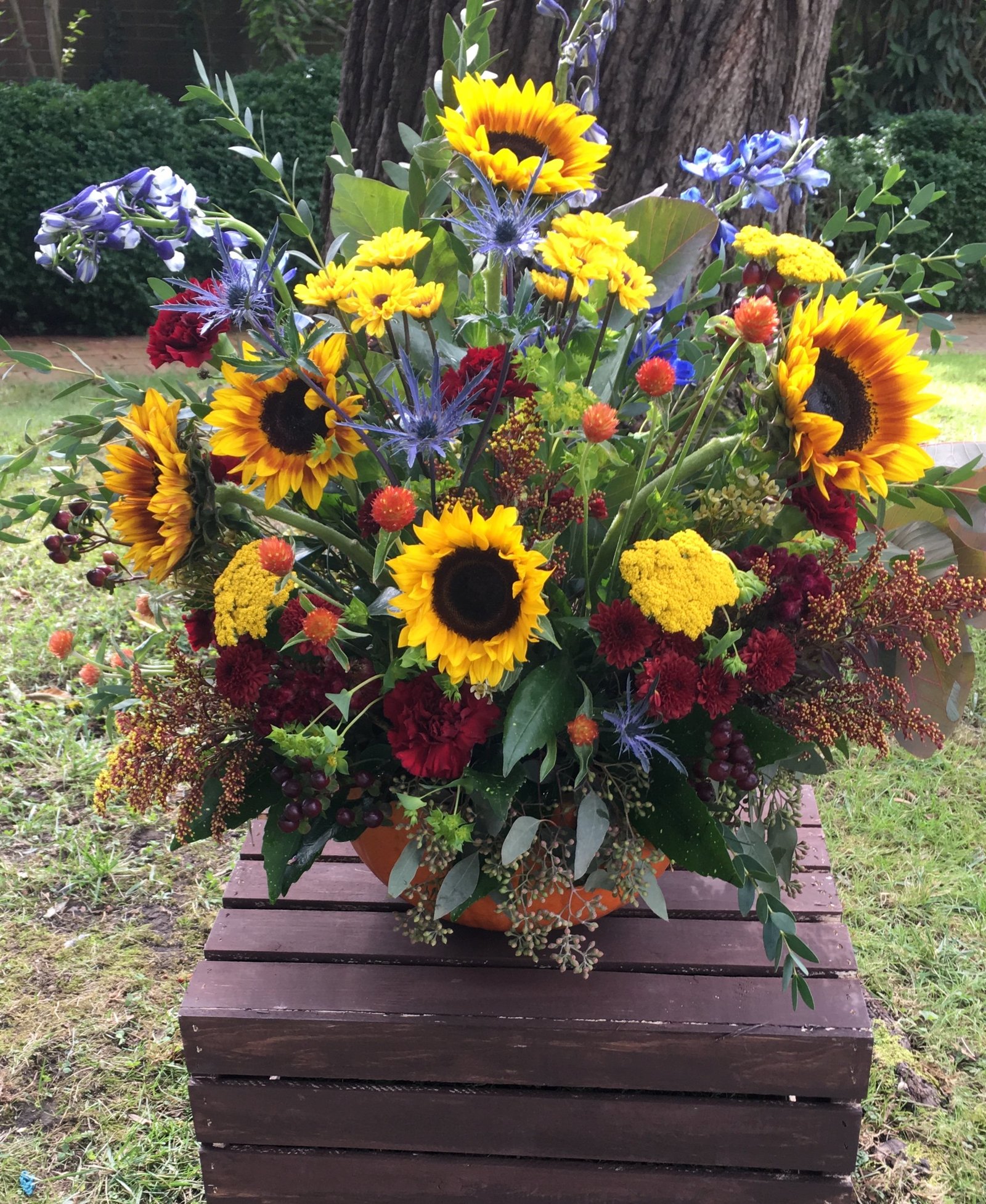 rustic sunflower and delphinium ceremony arrangement