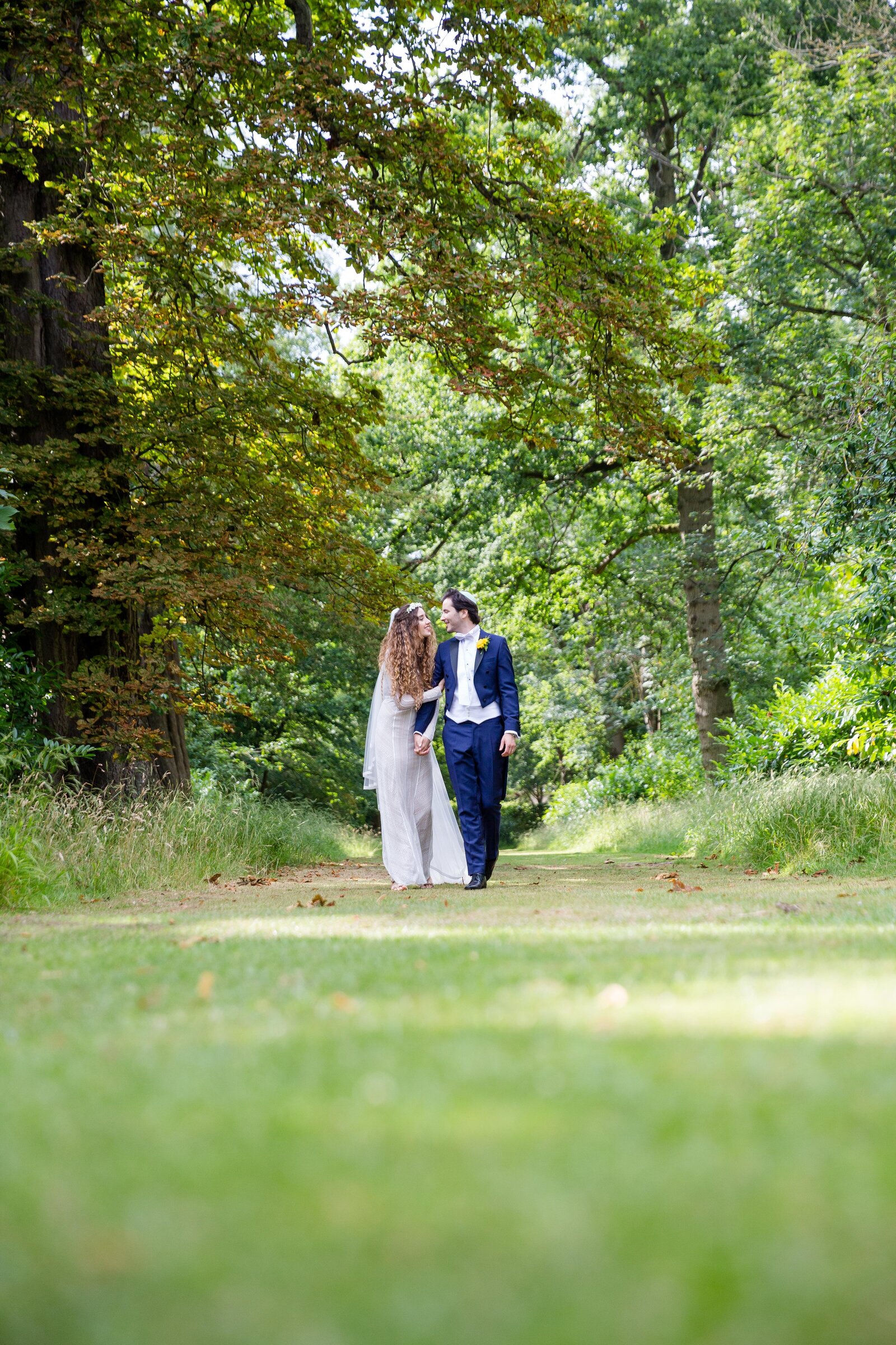 The Bride and Groom Walking through the woods at Wrest Park