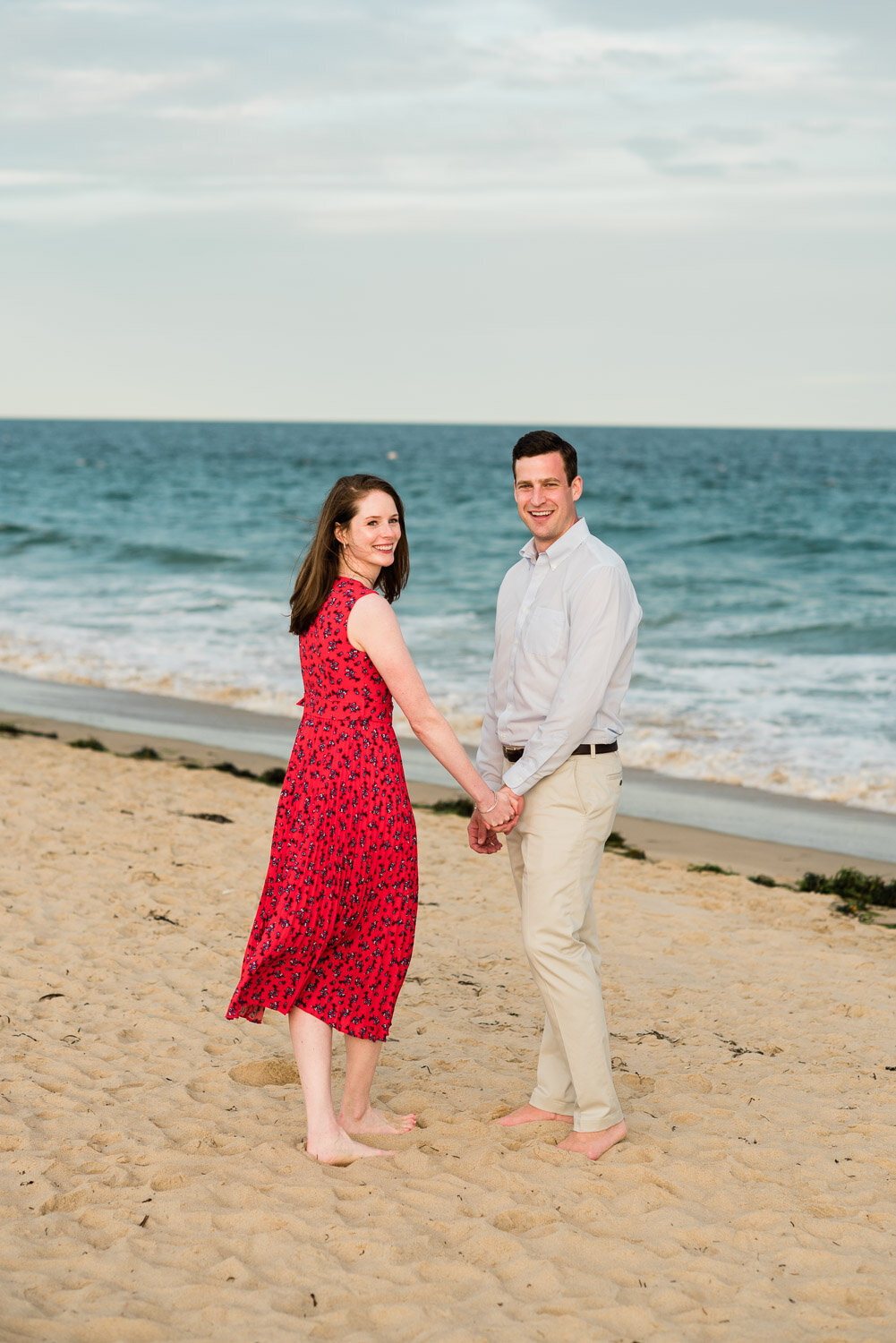 couple on beach walking away looking back
