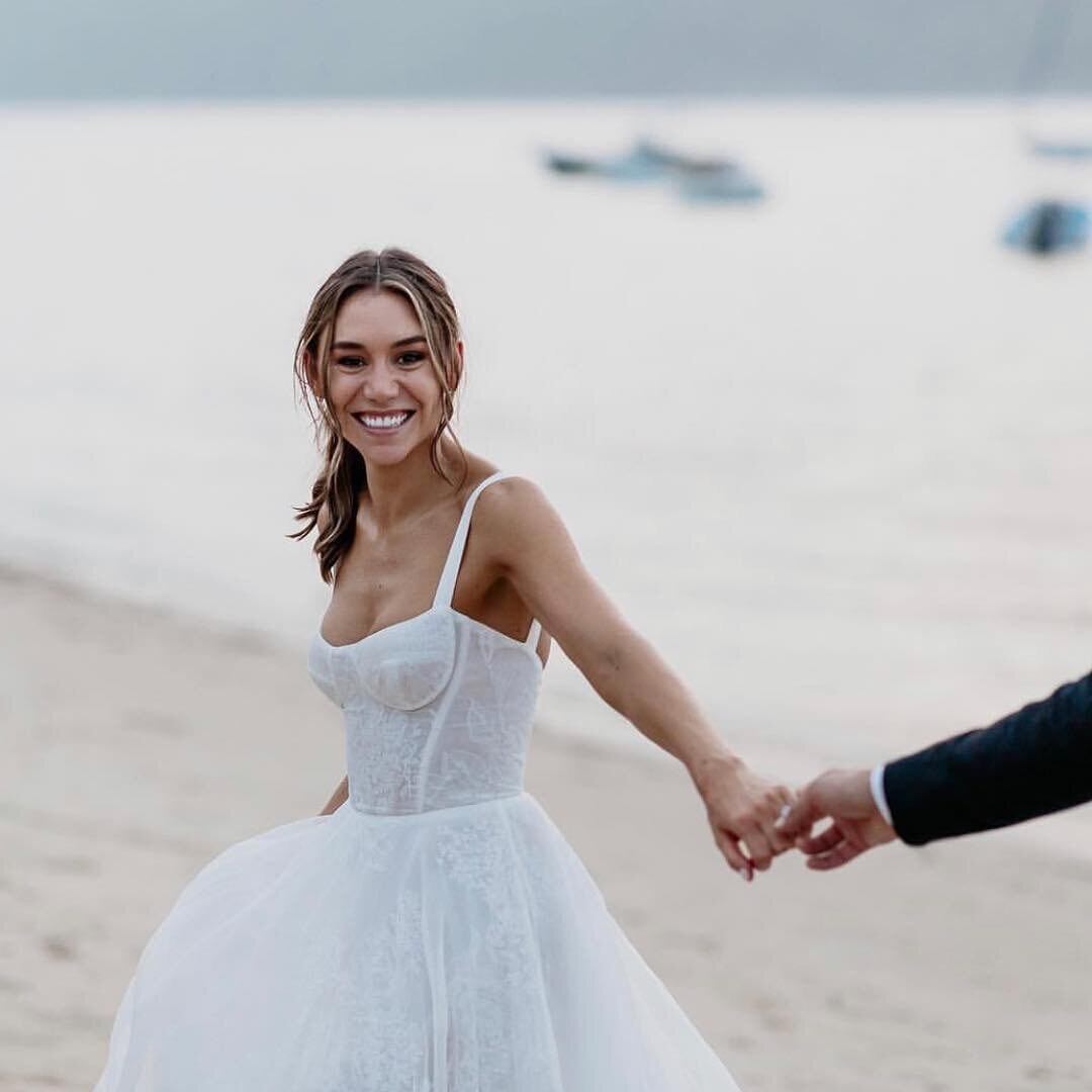 bride and groom holding hands on beach