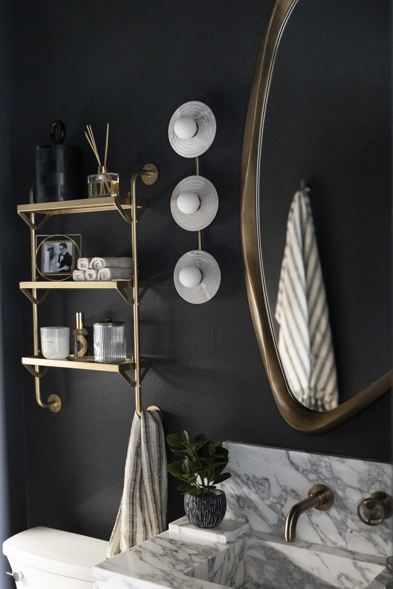 dewine design interiors moody guest bathroom with black painted walls and gold accents