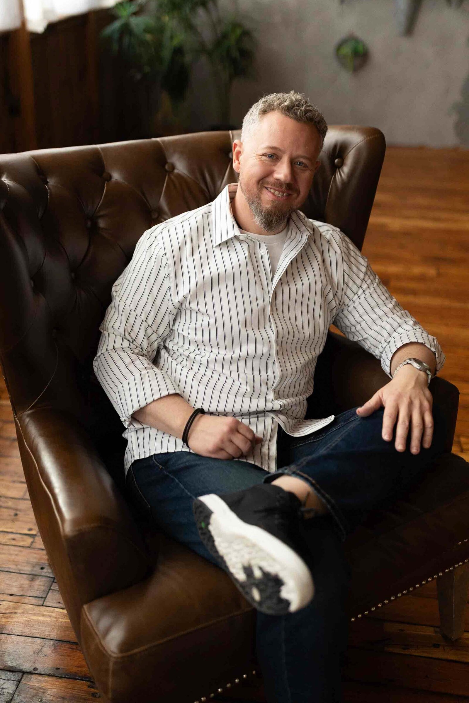 man in a stripe suite sitting on the couch