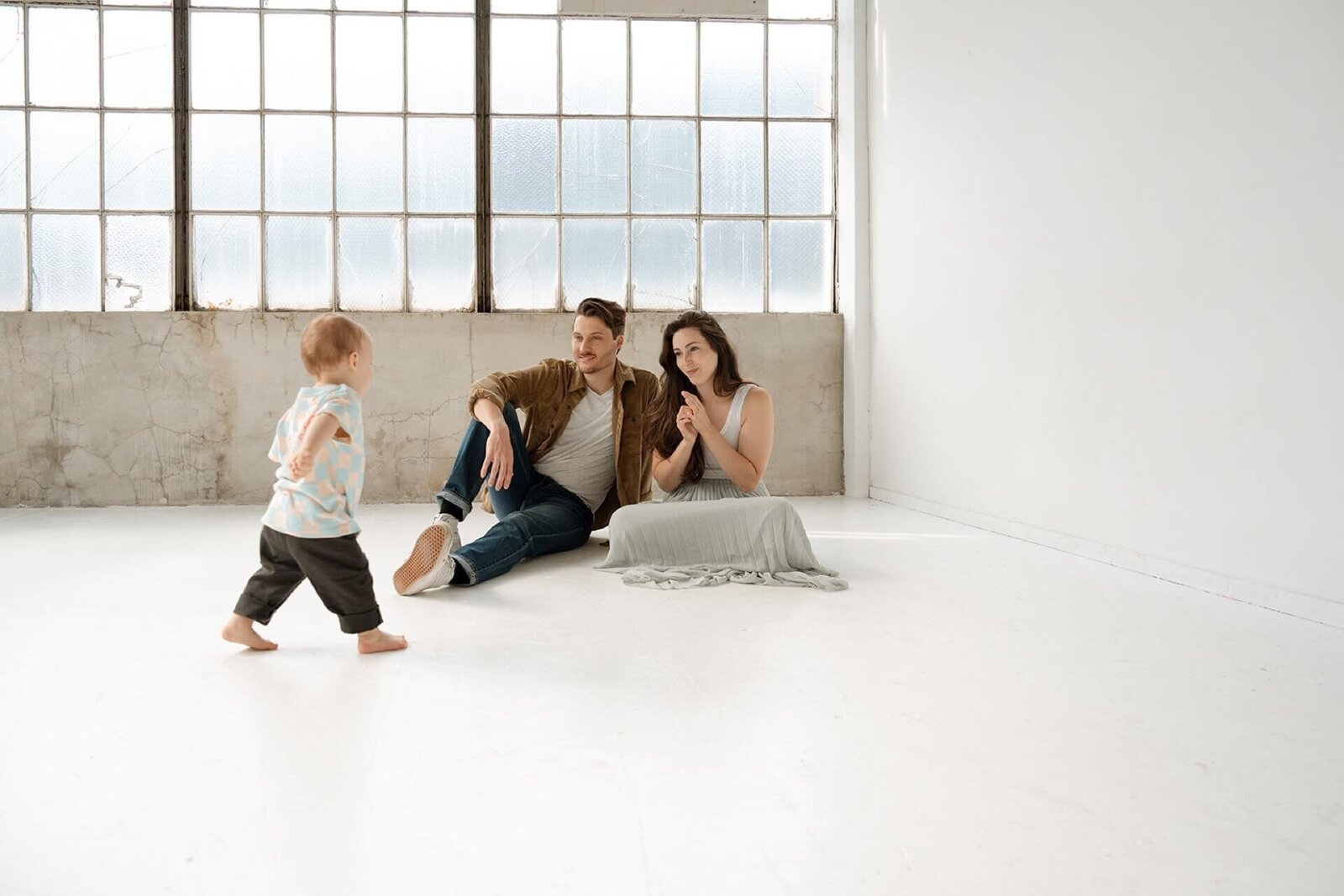 male and female in white studio with toddler baby boy