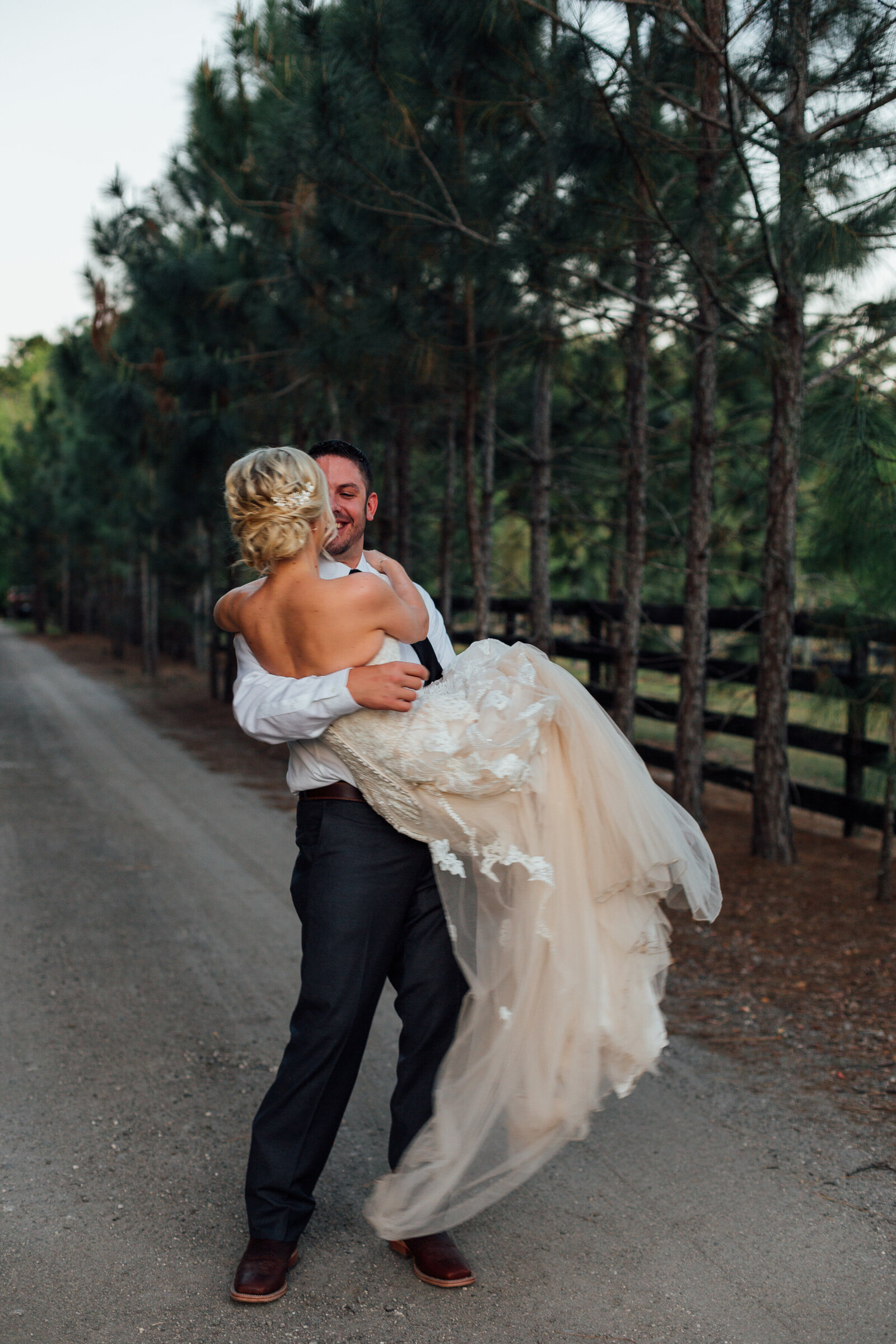groom-holding-bride-on-country-road-photo-iris-and-urchin-ryley