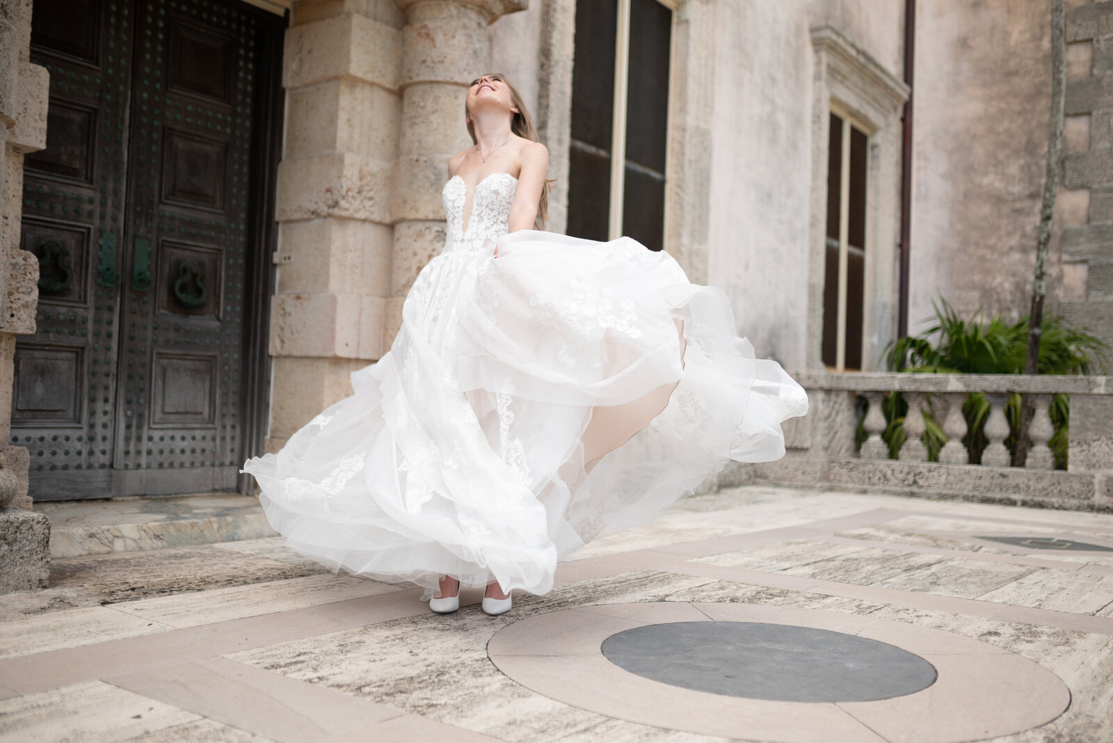 Bride twirling in her dress, her head thrown back with laughter