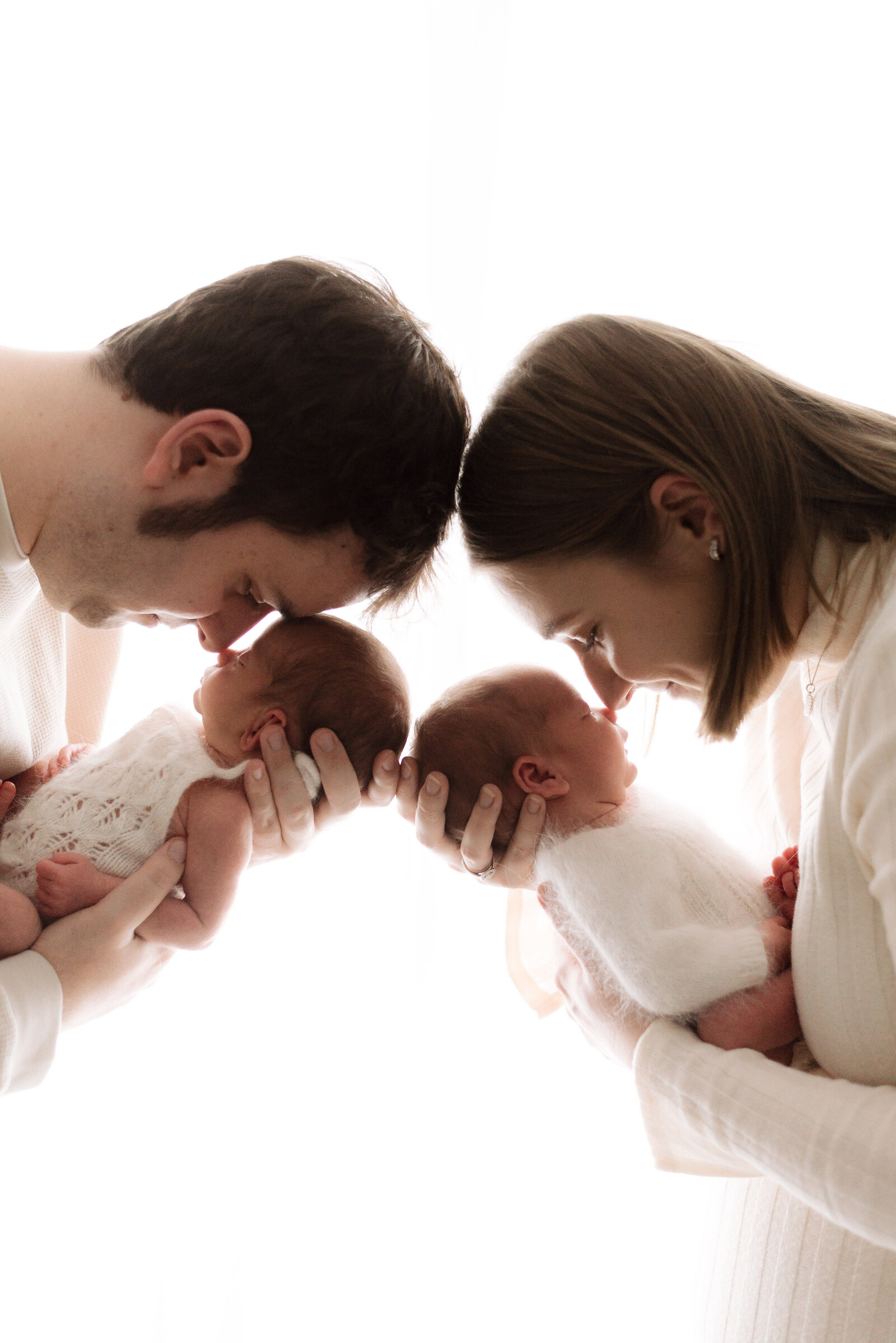 Newborn photoshoot with mum and dad holding their newborn twins