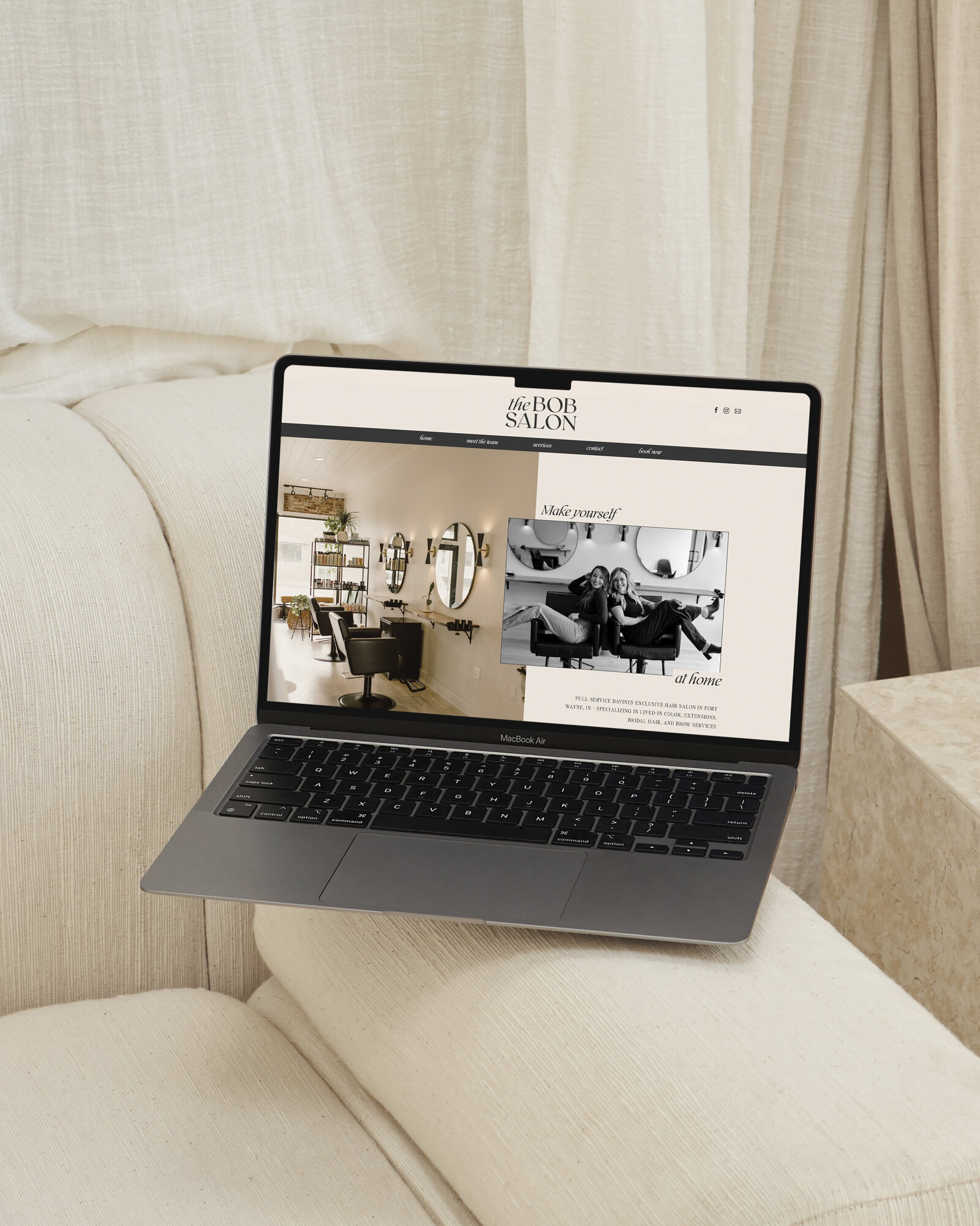 Laptop displaying a modern website on a cozy sofa