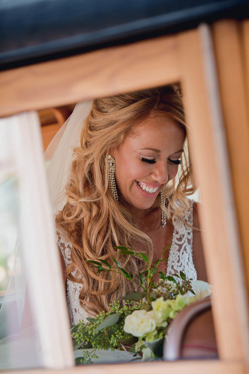 Bride smiles from a window of a vintage car, Destination wedding, Sarasota Garden Club, Florida
