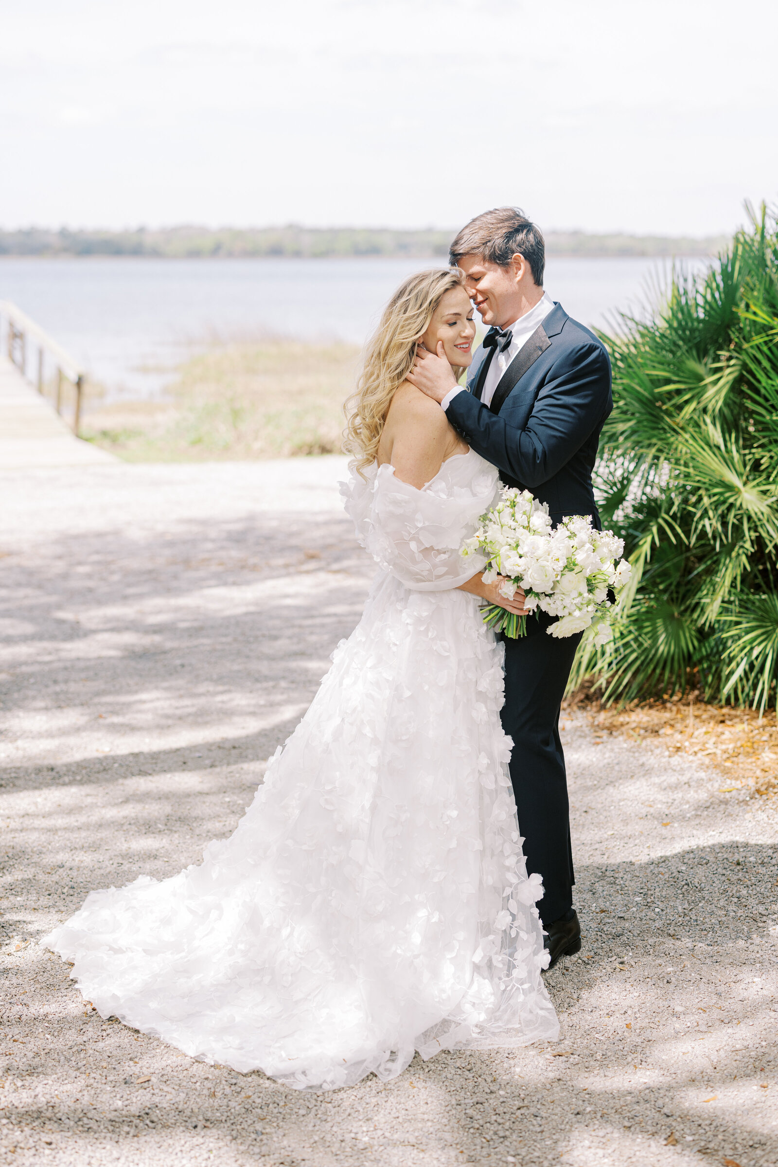 Bride and groom standing in front of the dock at Lowndes Grove