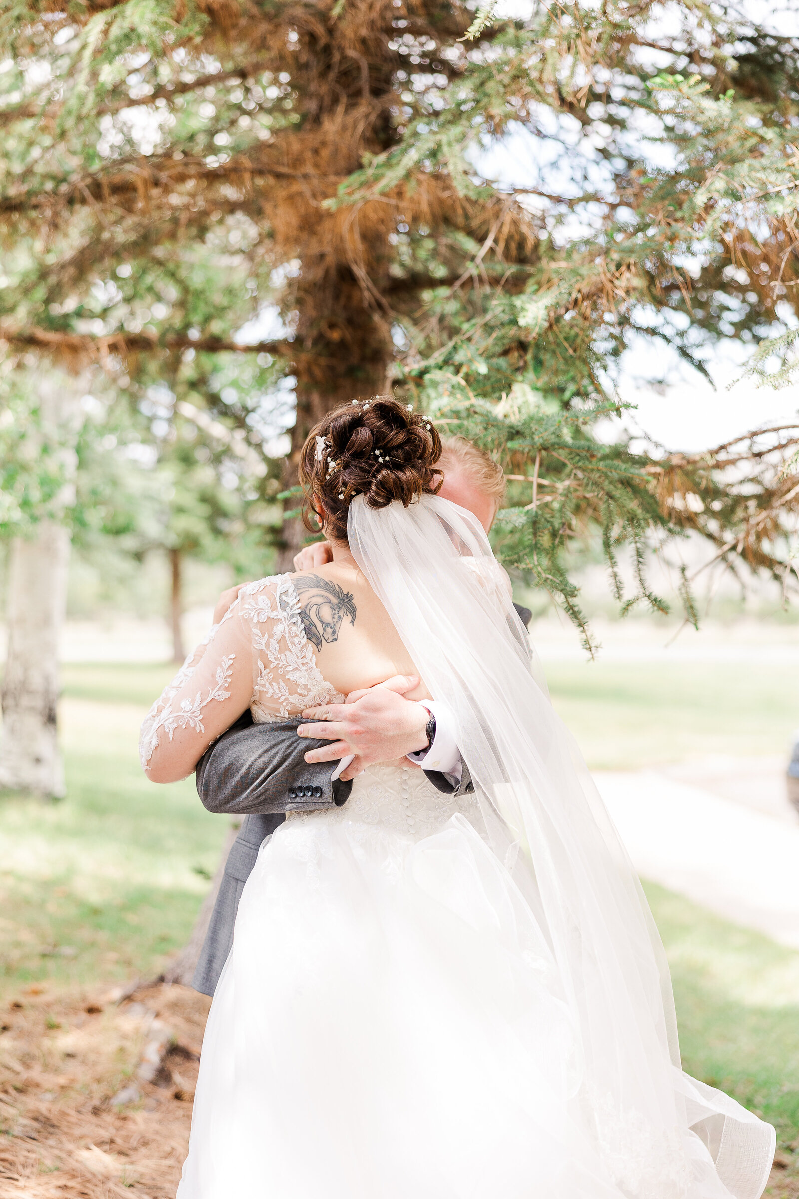 Bride and groom embracing during their first look at a Ridgway State Park wedding, capturing a heartfelt moment
