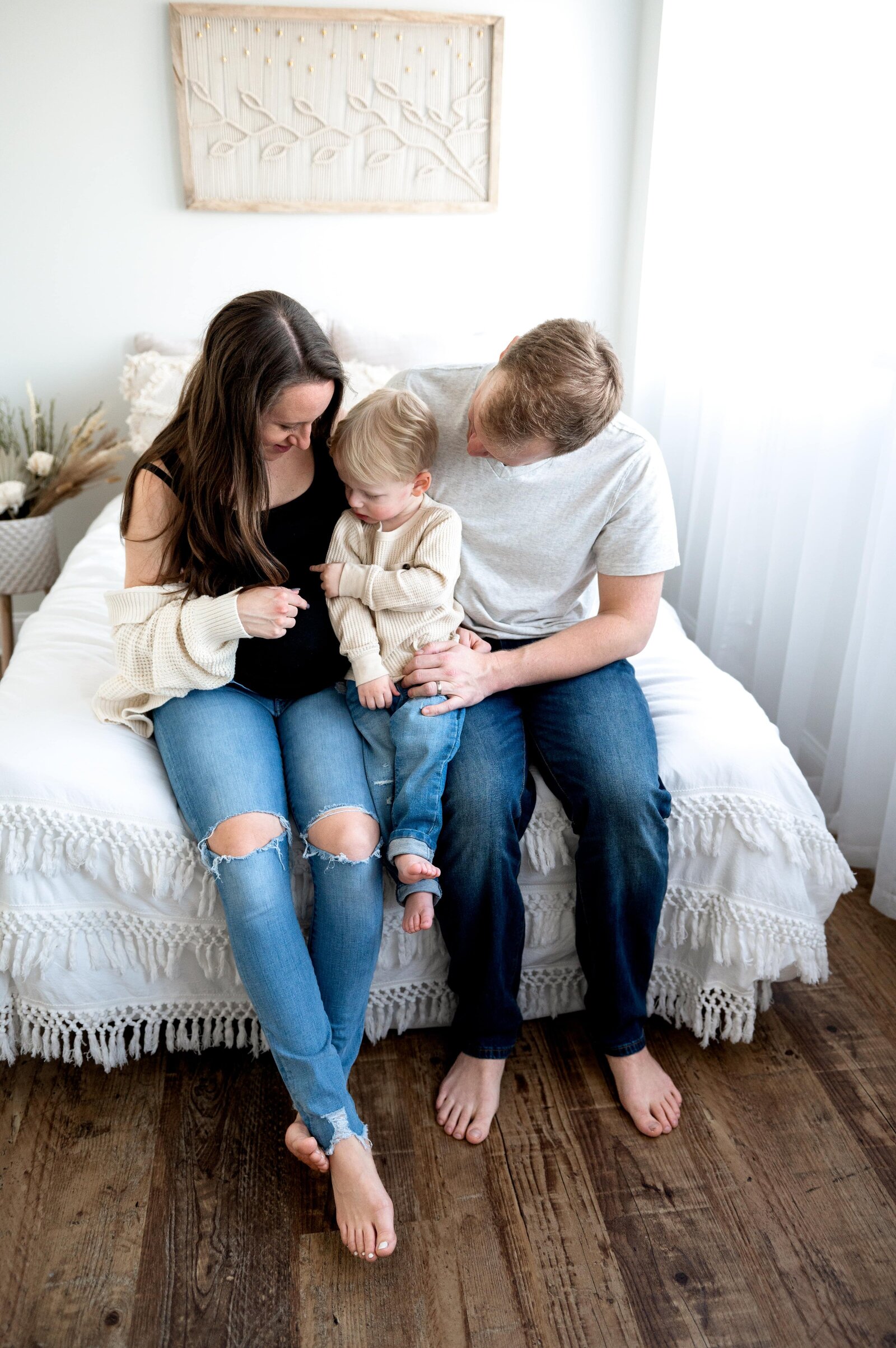 little boy pointing to moms belly