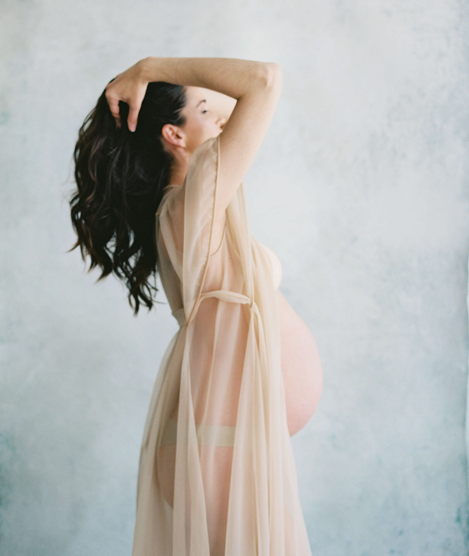 Dramatic studio maternity session with creative lighting highlighting the silhouette of the mother-to-be, taken by Bay Area Maternity Photographer, Laurel Smith.