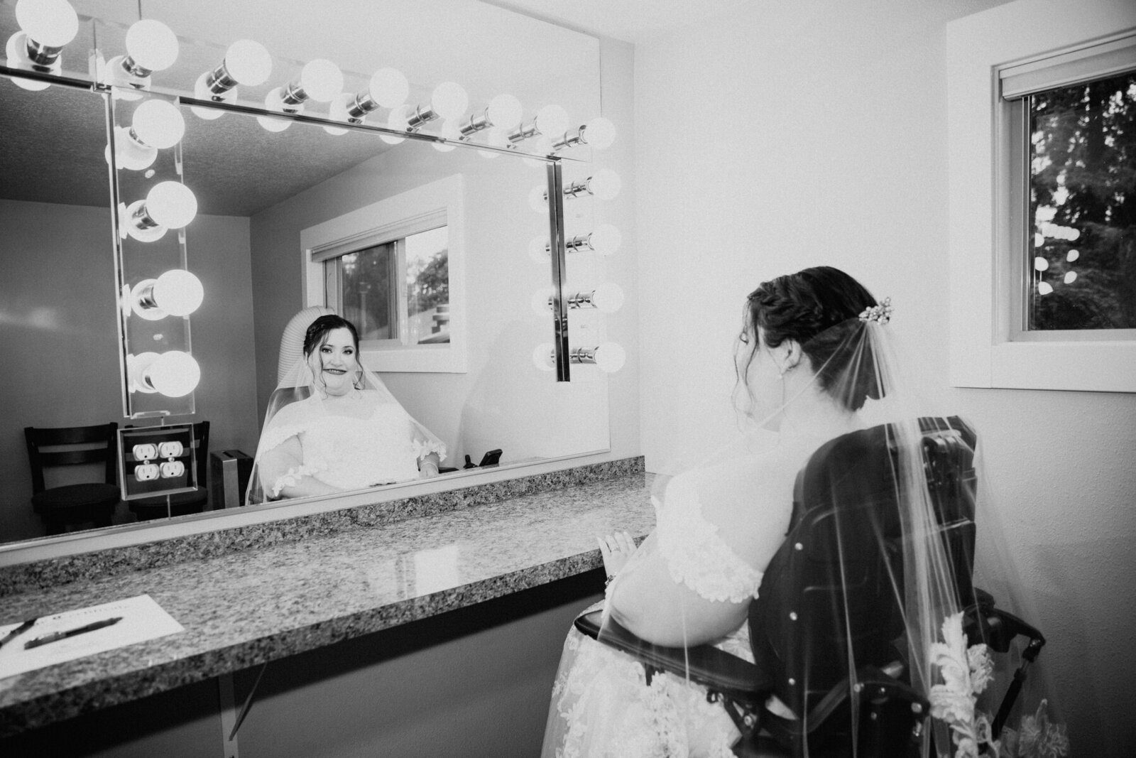 a bride wearing a custom lace veil posing in the mirror