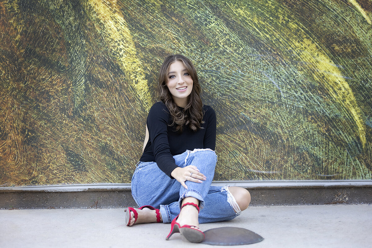 Senior girl poses in front of Arts District mural