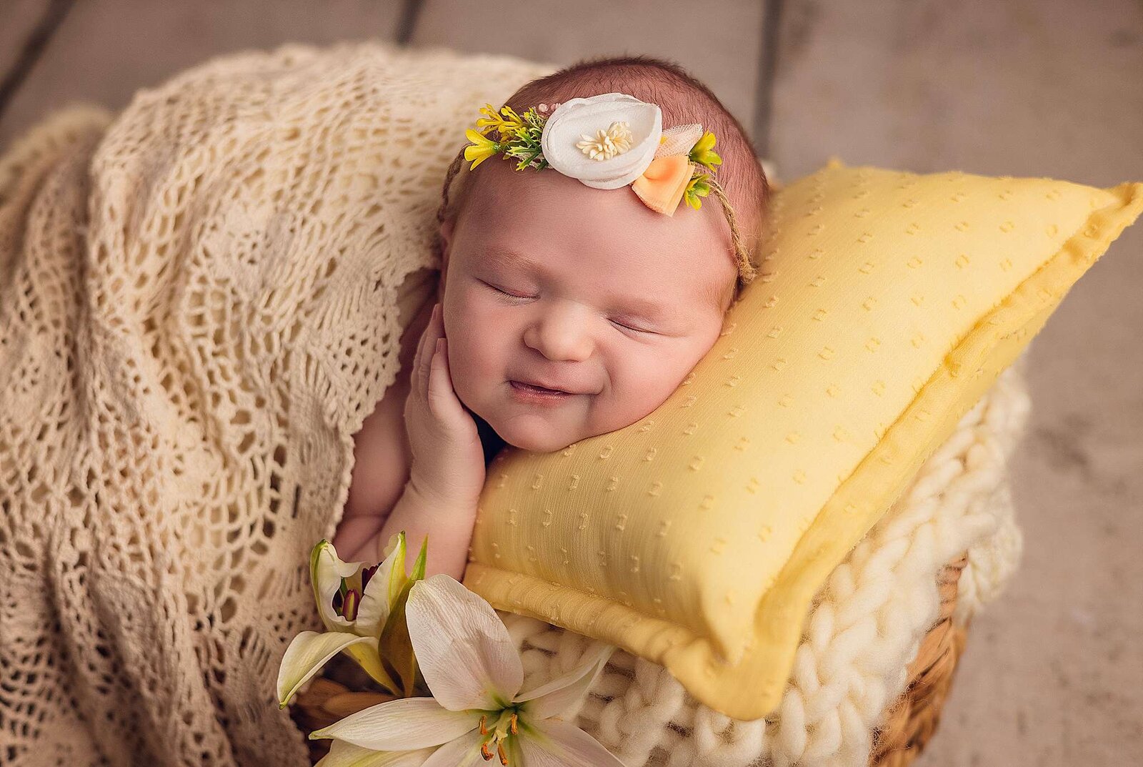 A peaceful newborn girl sleeps in a basket surrounded by vibrant yellow flowers, captured by Bia Schaefer Photography.