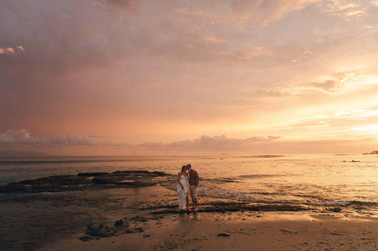 bride and groom sitting on a piano in a field