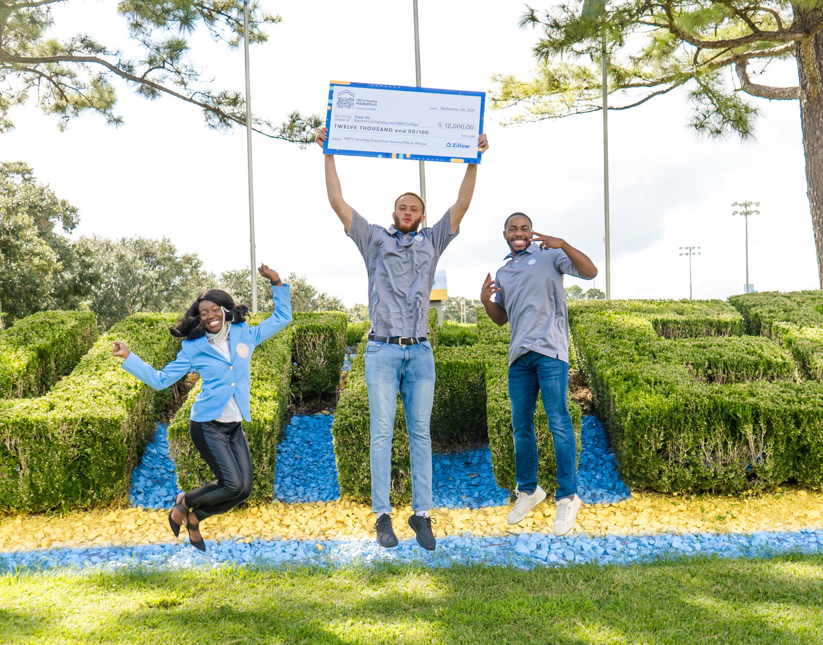 Students jumping with check