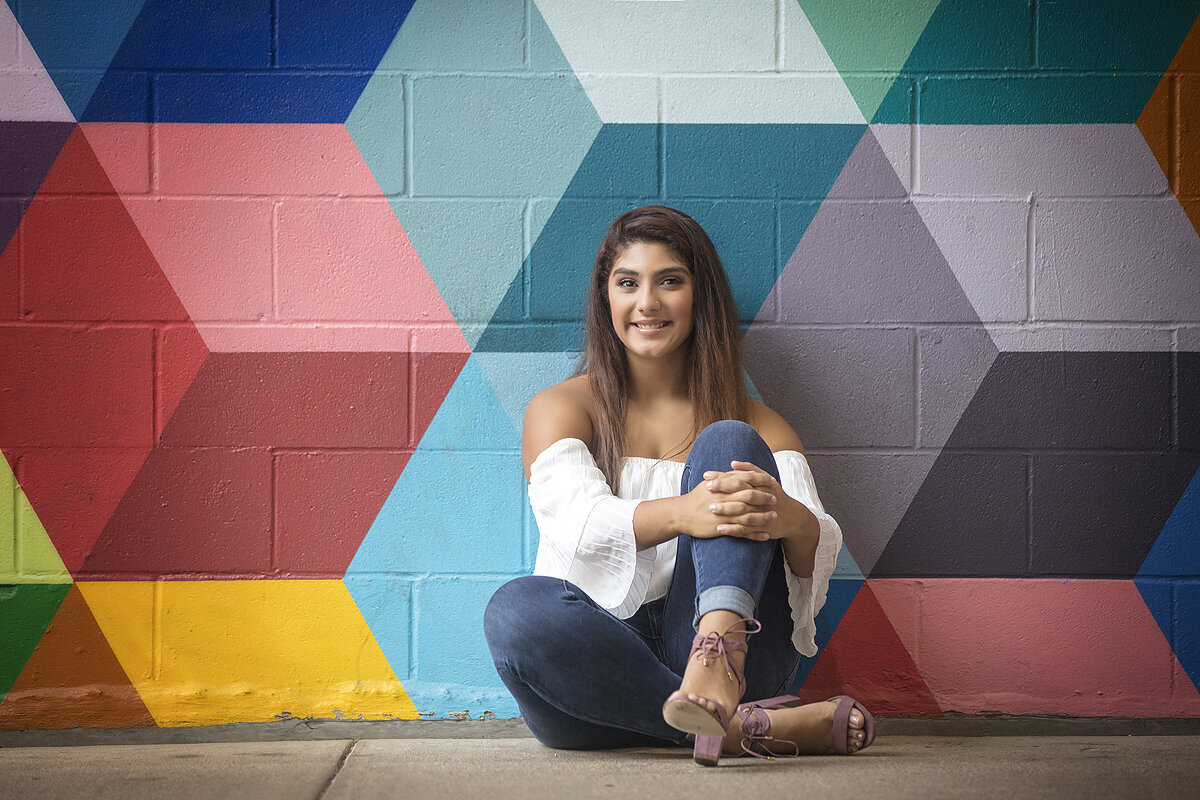 Senior girl poses in front of West Village mural