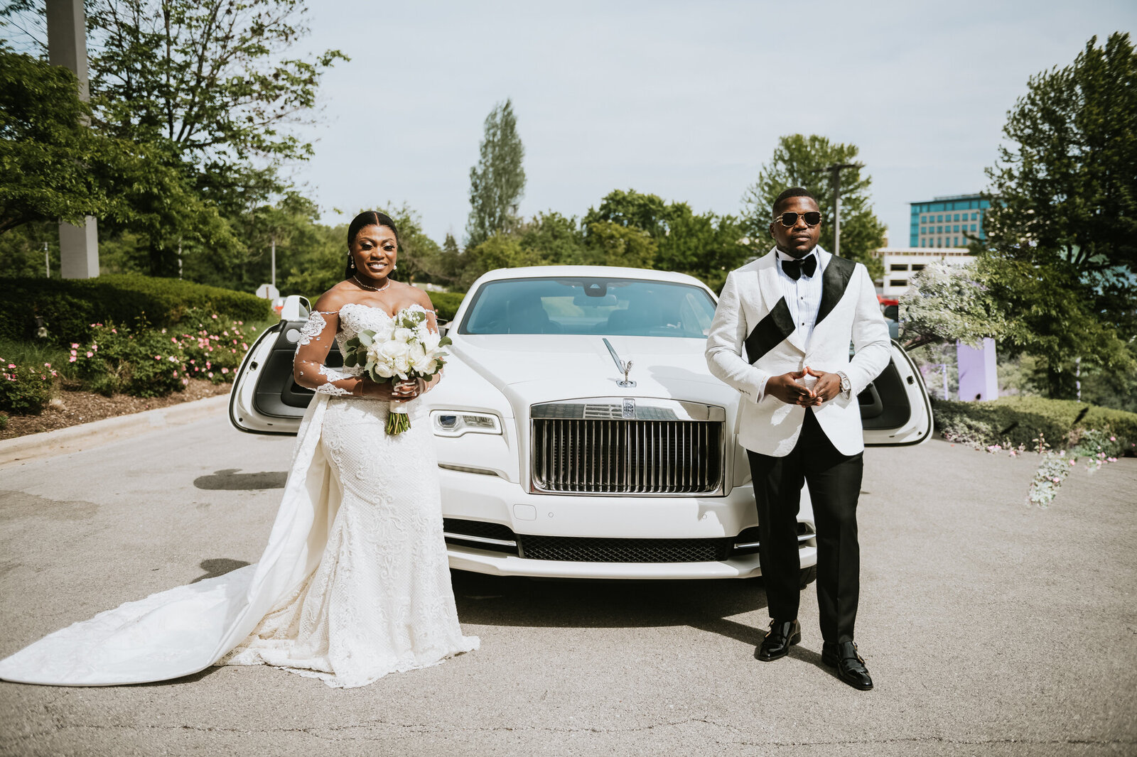 bride and groom in front of a luxury getaway car