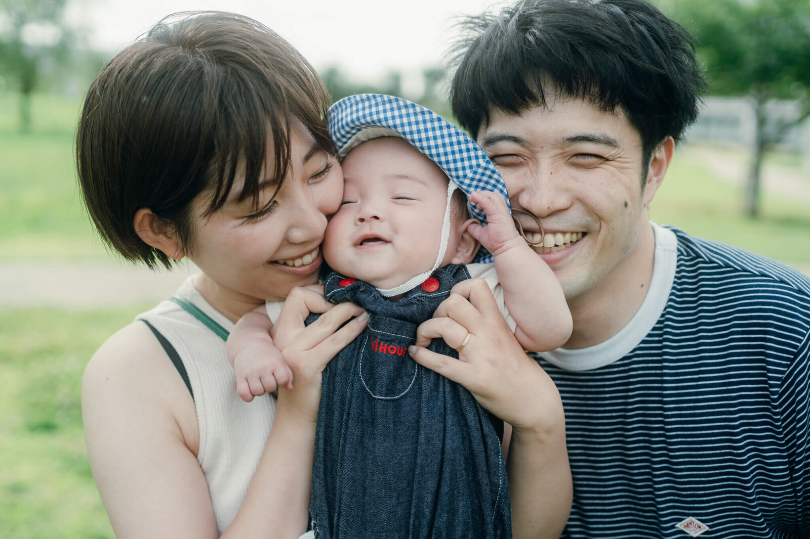赤ちゃんに顔を寄せる両親