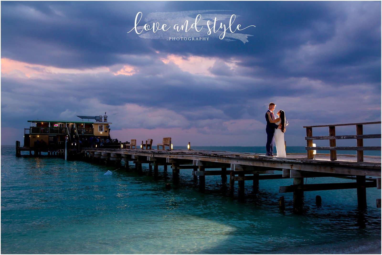 Rod and Reel Pier Wedding Photography of bride and groom with backlight at sunset