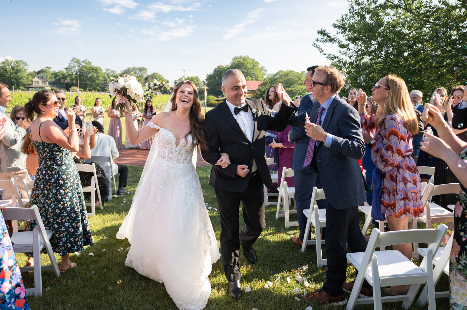 Happy bride and groom walking down the aisle after getting married outside a winery in Cape May NJ