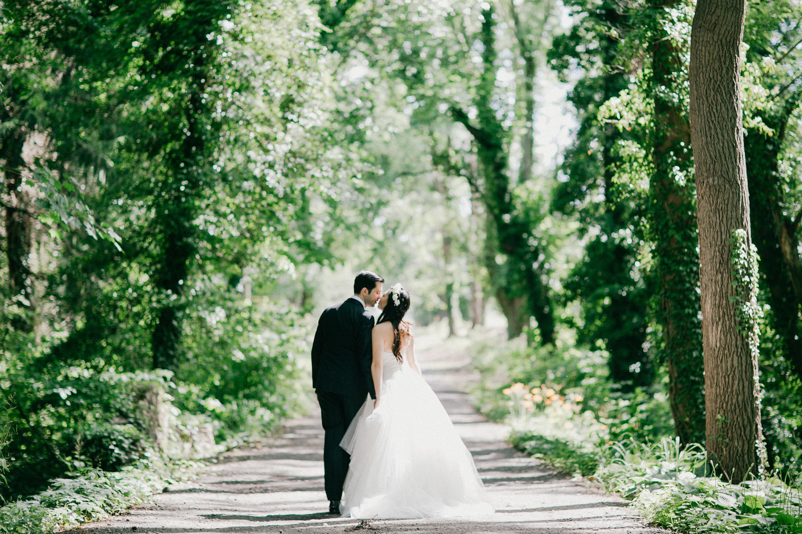 Bride and groom walking along the path at this woodsy wedding venue.