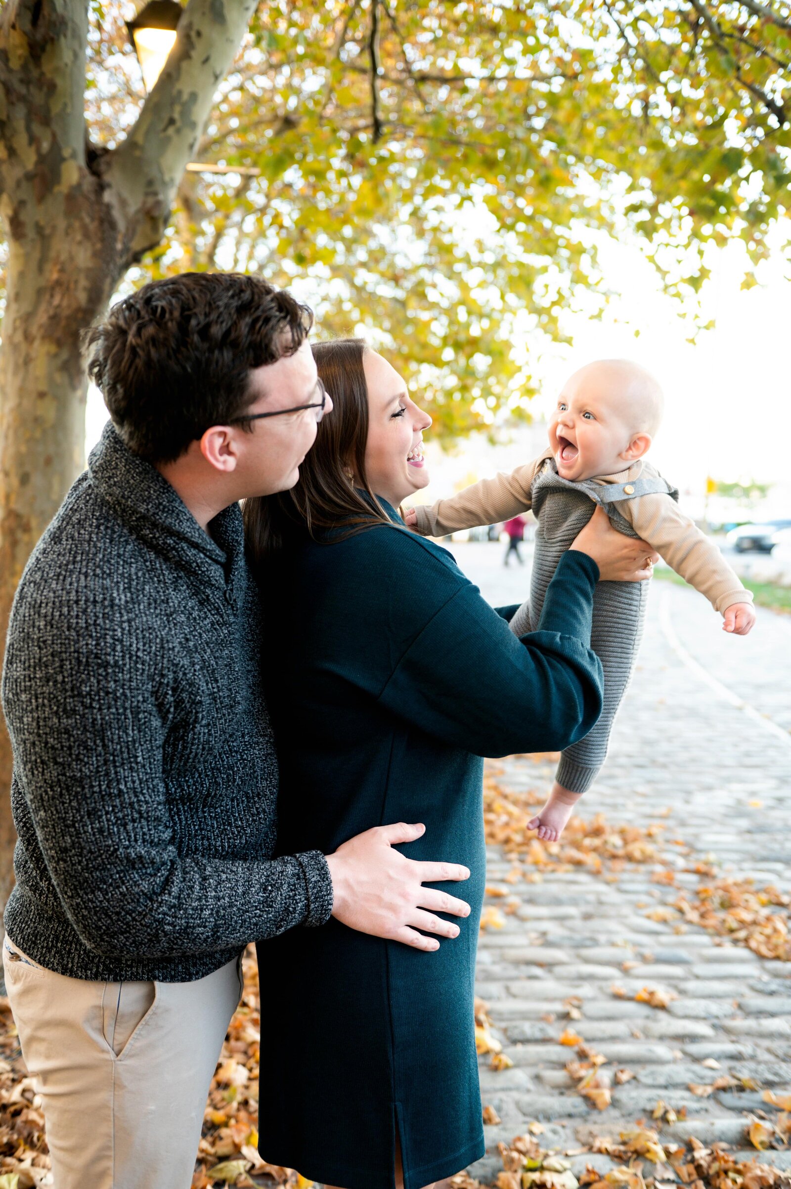 mom holding baby as he smiles at a family photoshoot