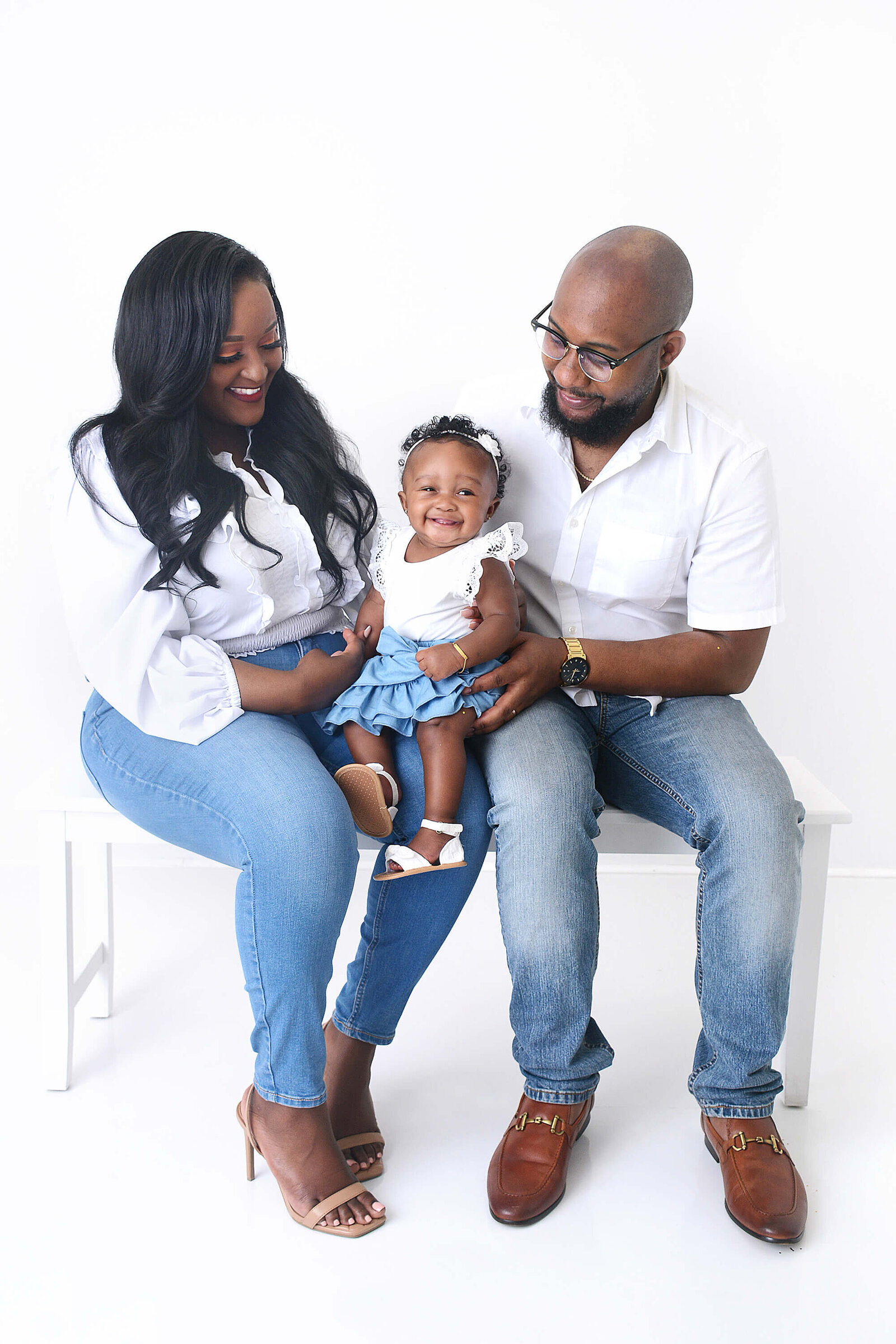 family smiles at their baby at their photoshoot